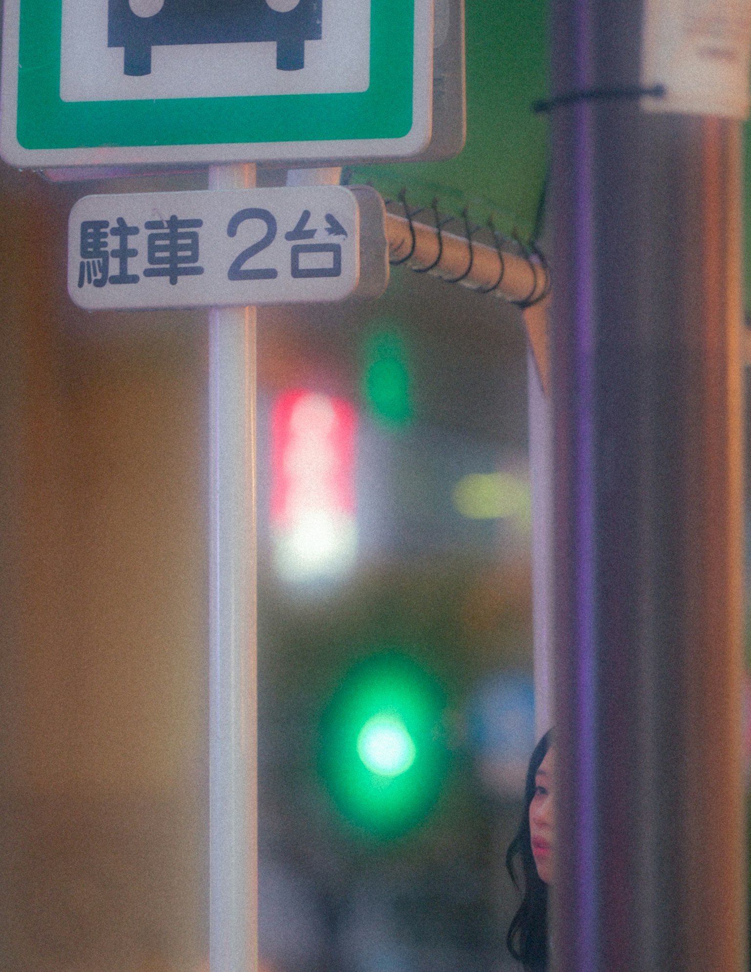 街の看板と女性の姿が見える夜の風景