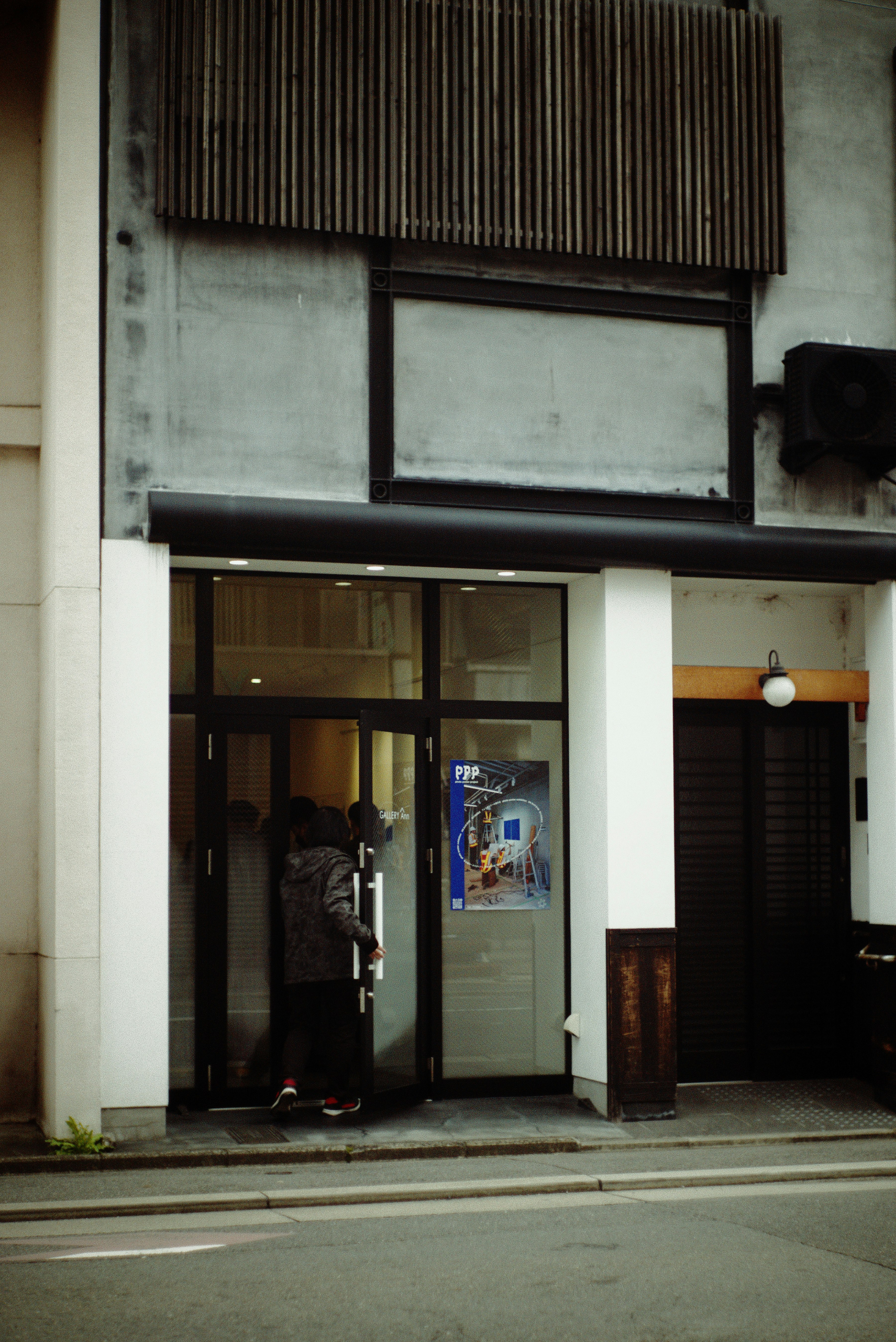 京都の路地に面した建物の入口と掲示ポスターのある通りの風景