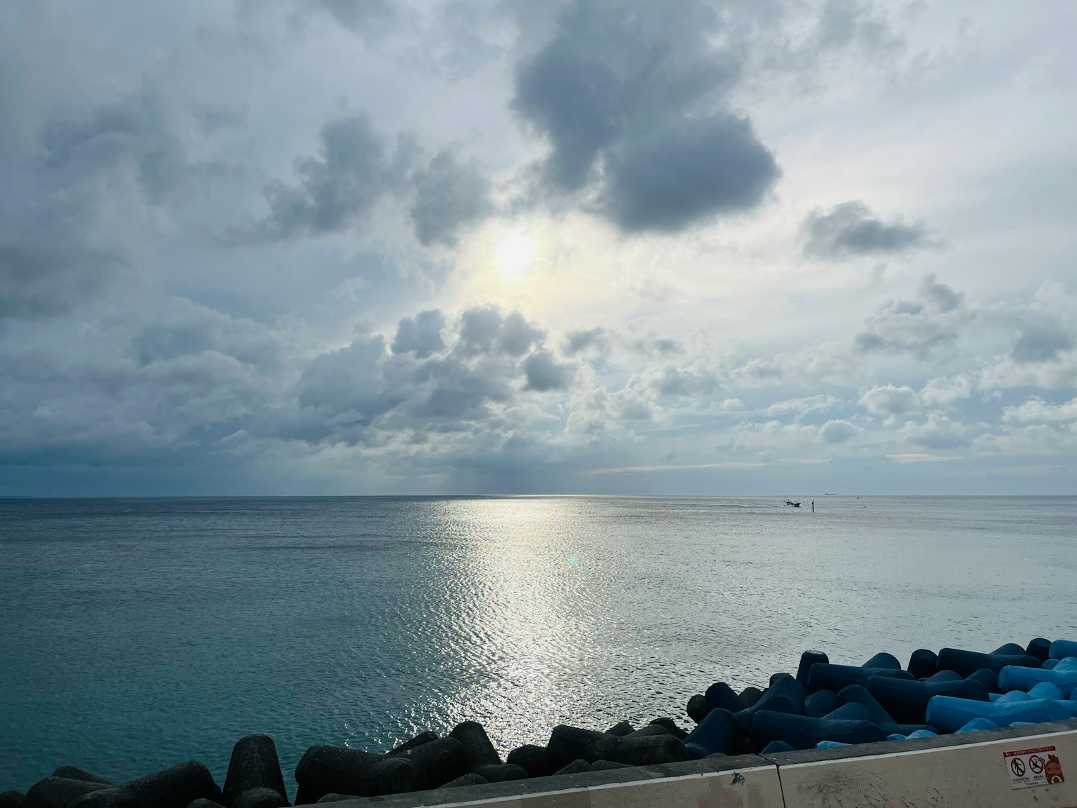 Ruhiges Meer mit bewölktem Himmel und Lichtreflexion