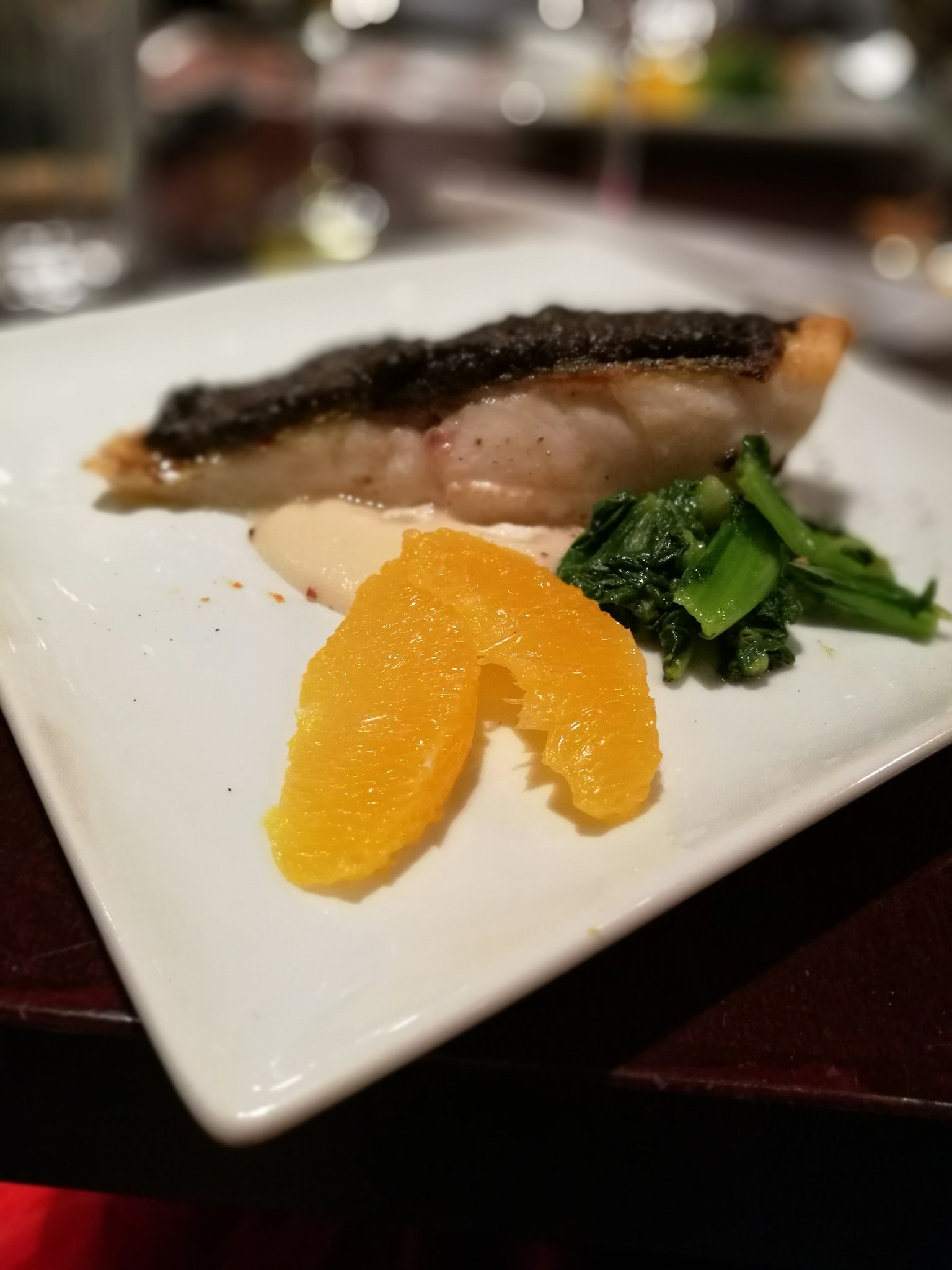 盘子上的鱼片与橙子片和炒青菜