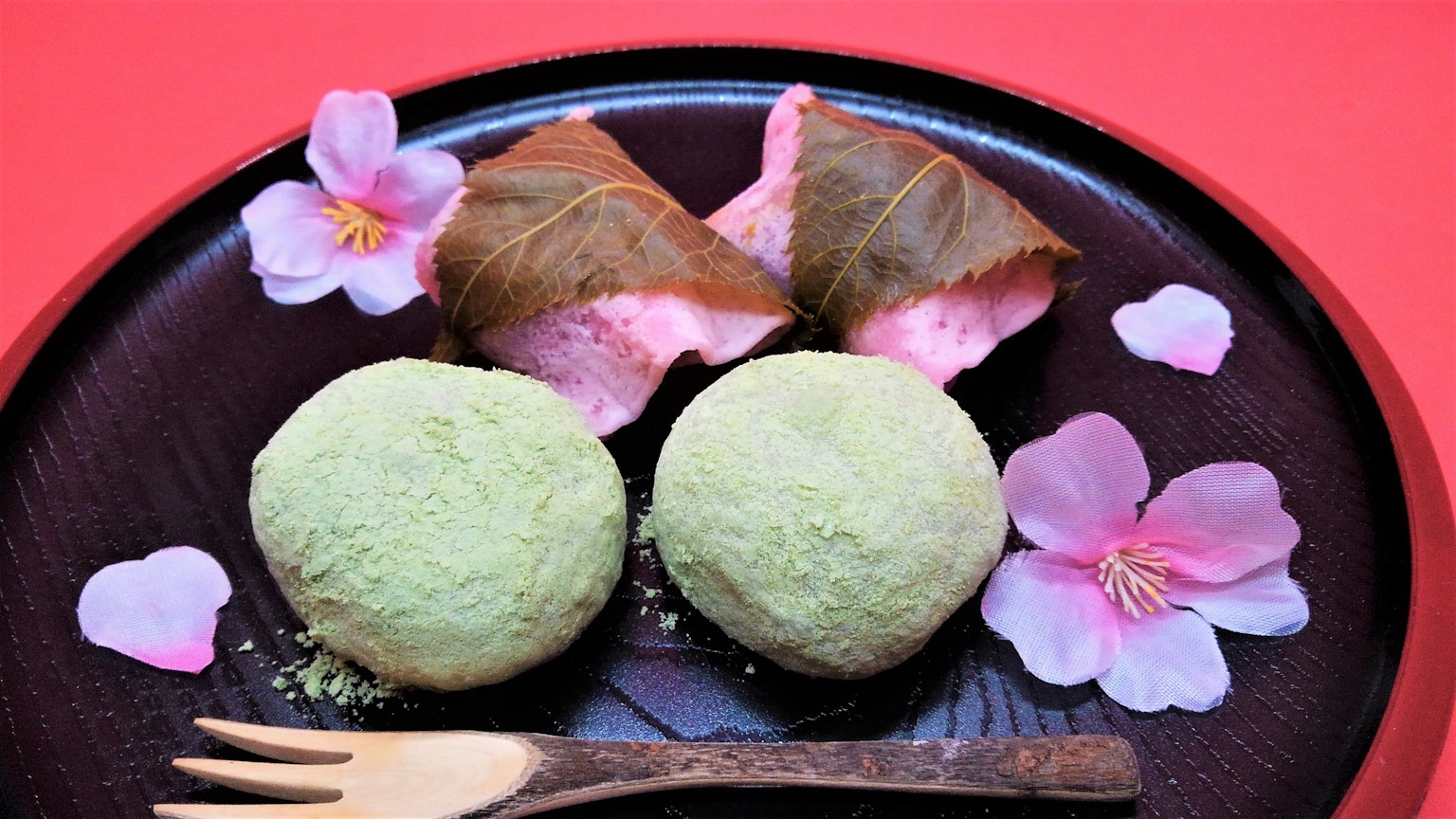 Un piatto con gnocchi verdi e mochi di sakura decorati con petali di ciliegio