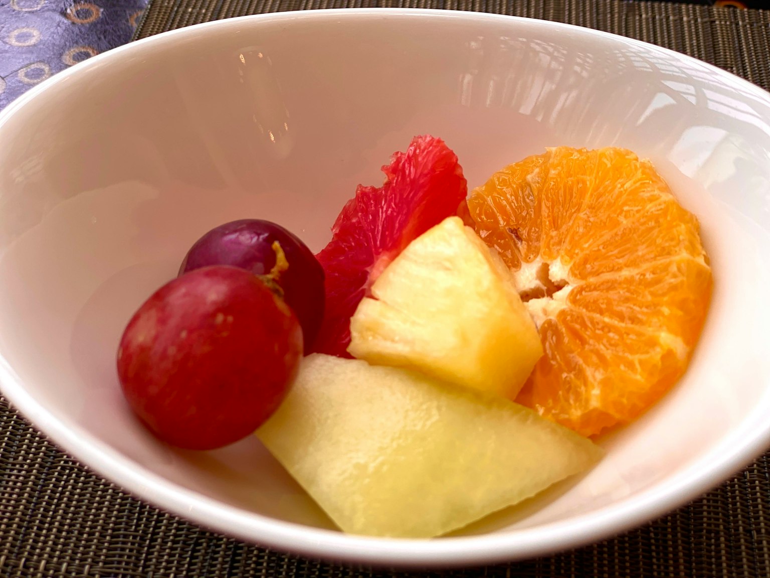 A colorful assortment of fruits in a white bowl