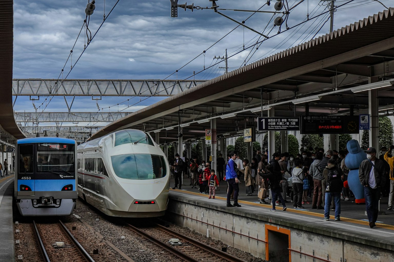 Scene of a train station with passengers and two trains