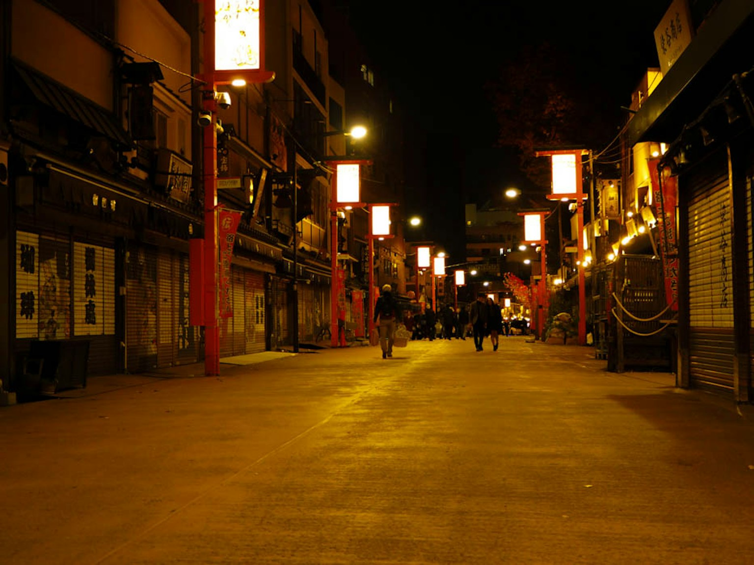 ฉากถนนยามค่ำคืนที่มีโคมไฟแดงและผู้คนเดิน