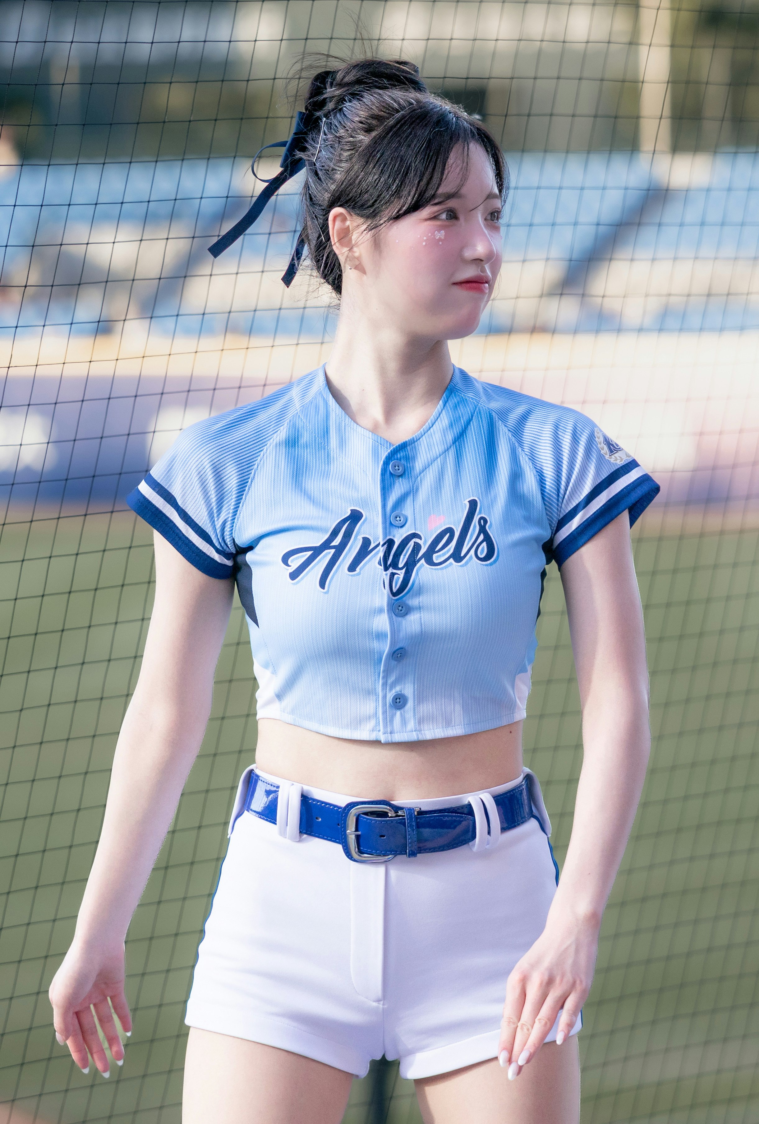 青いユニフォームの女性がスタジアムで立つ