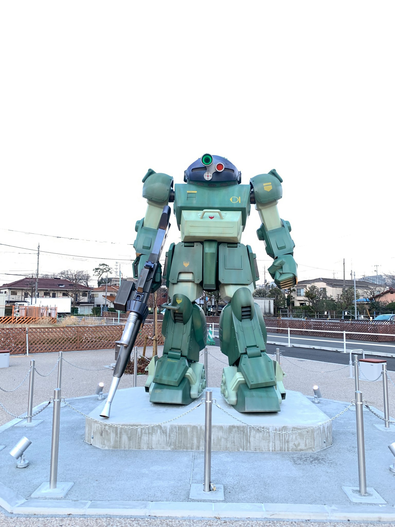 A large green robot statue standing in an outdoor setting