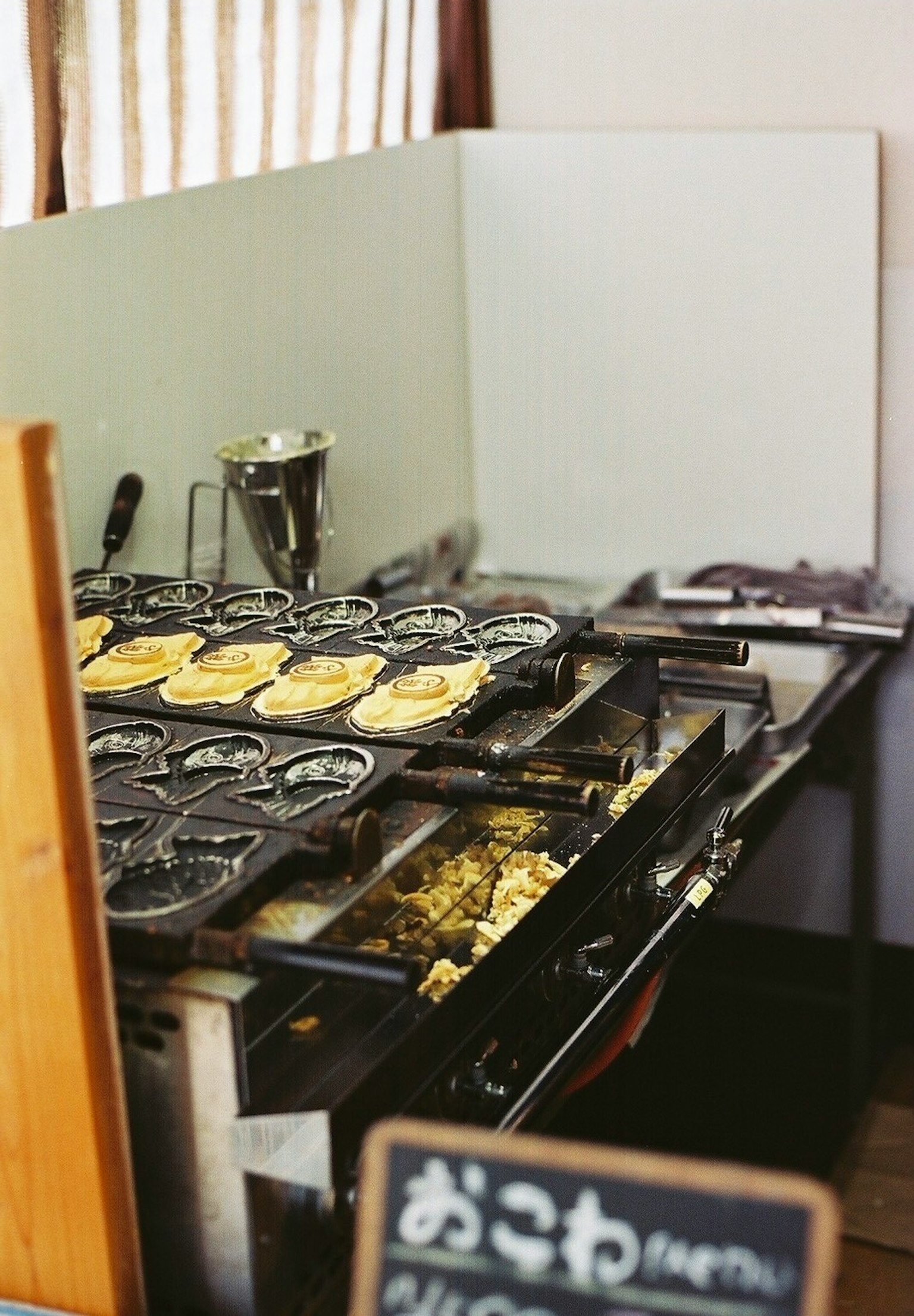 Estación de cocina de okonomiyaki con okonomiyaki a la parrilla e ingredientes