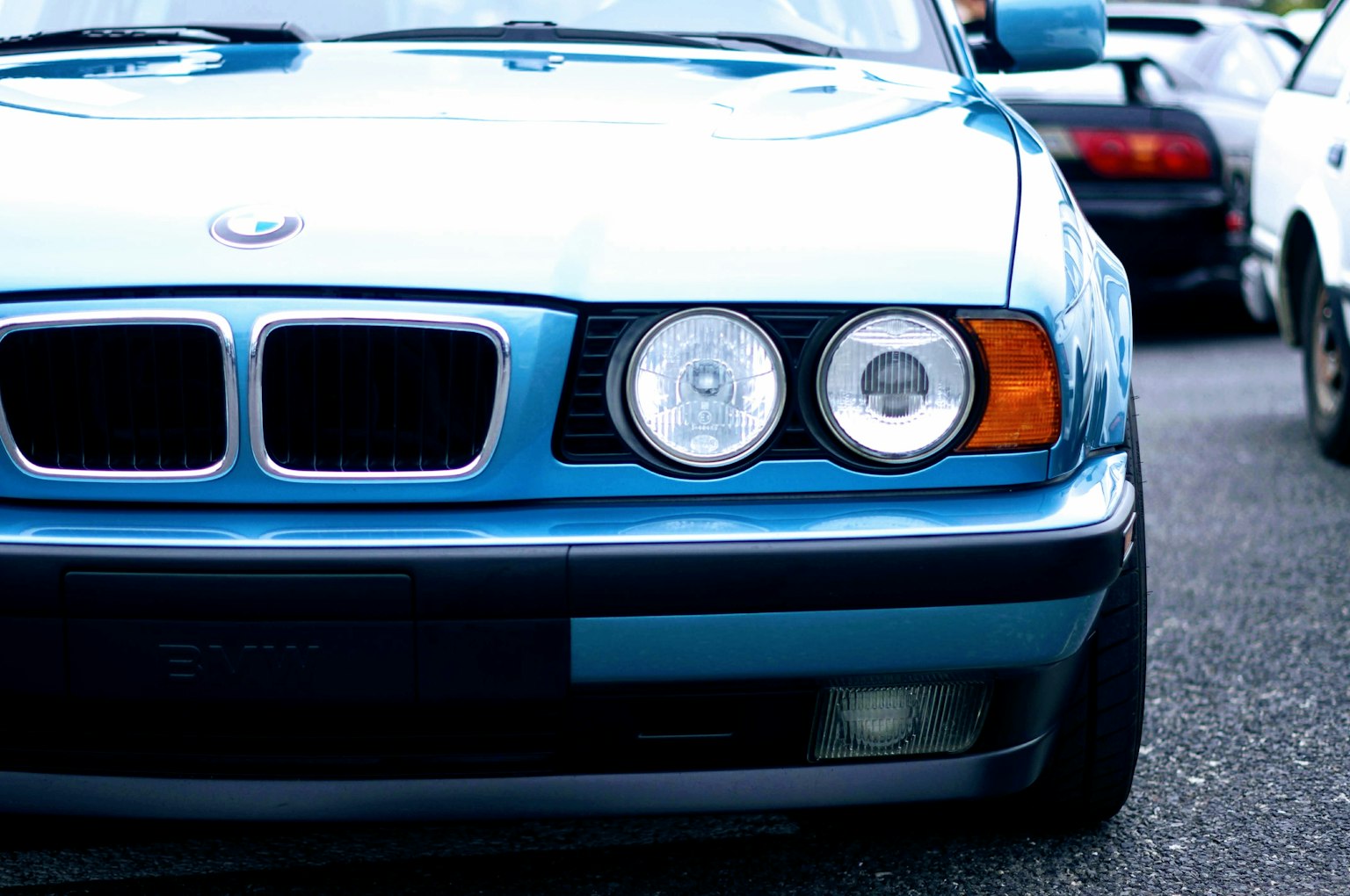 Primo piano di un'auto BMW blu con due fari rotondi e griglia distintiva