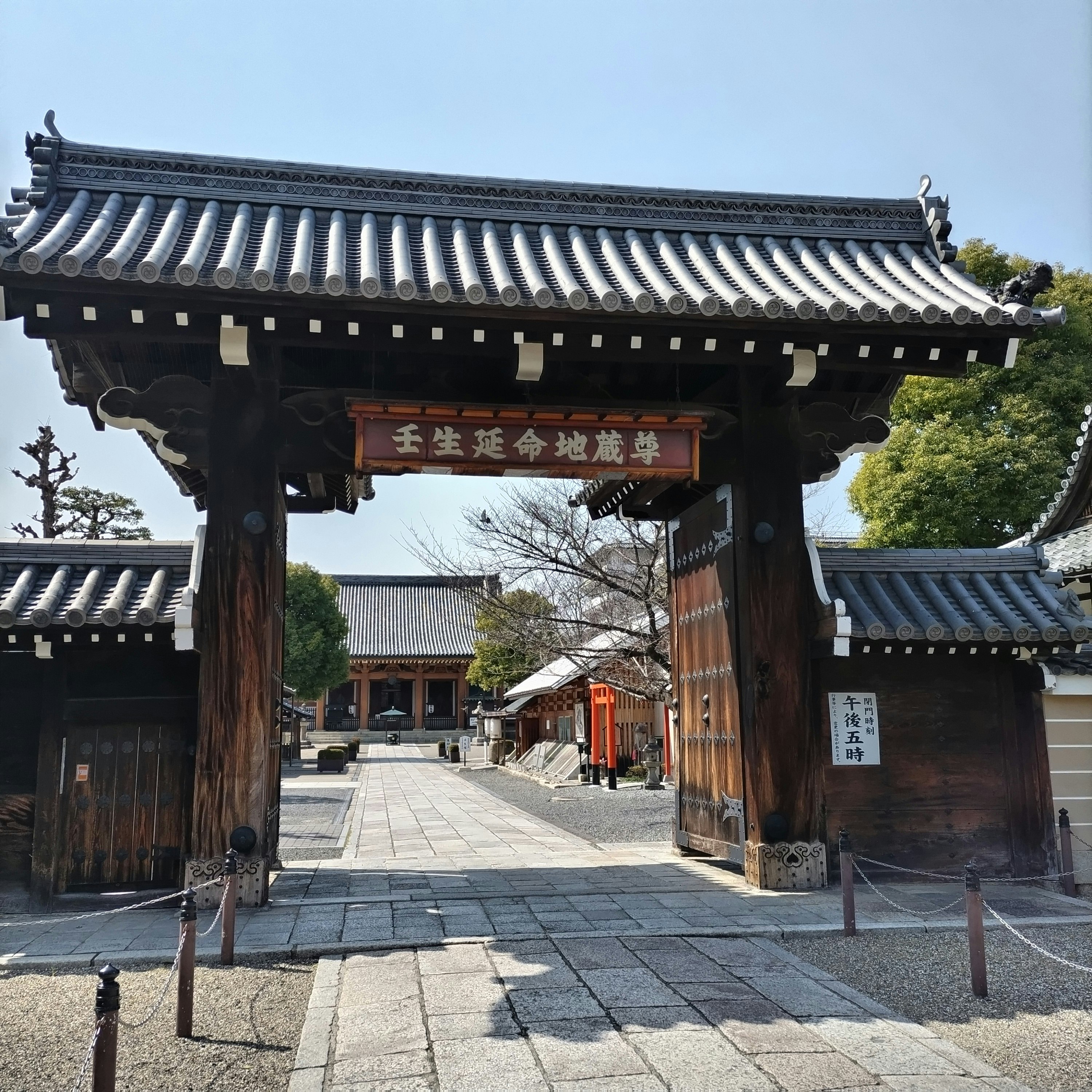木造の山門と石畳の参道が続く寺院の入口