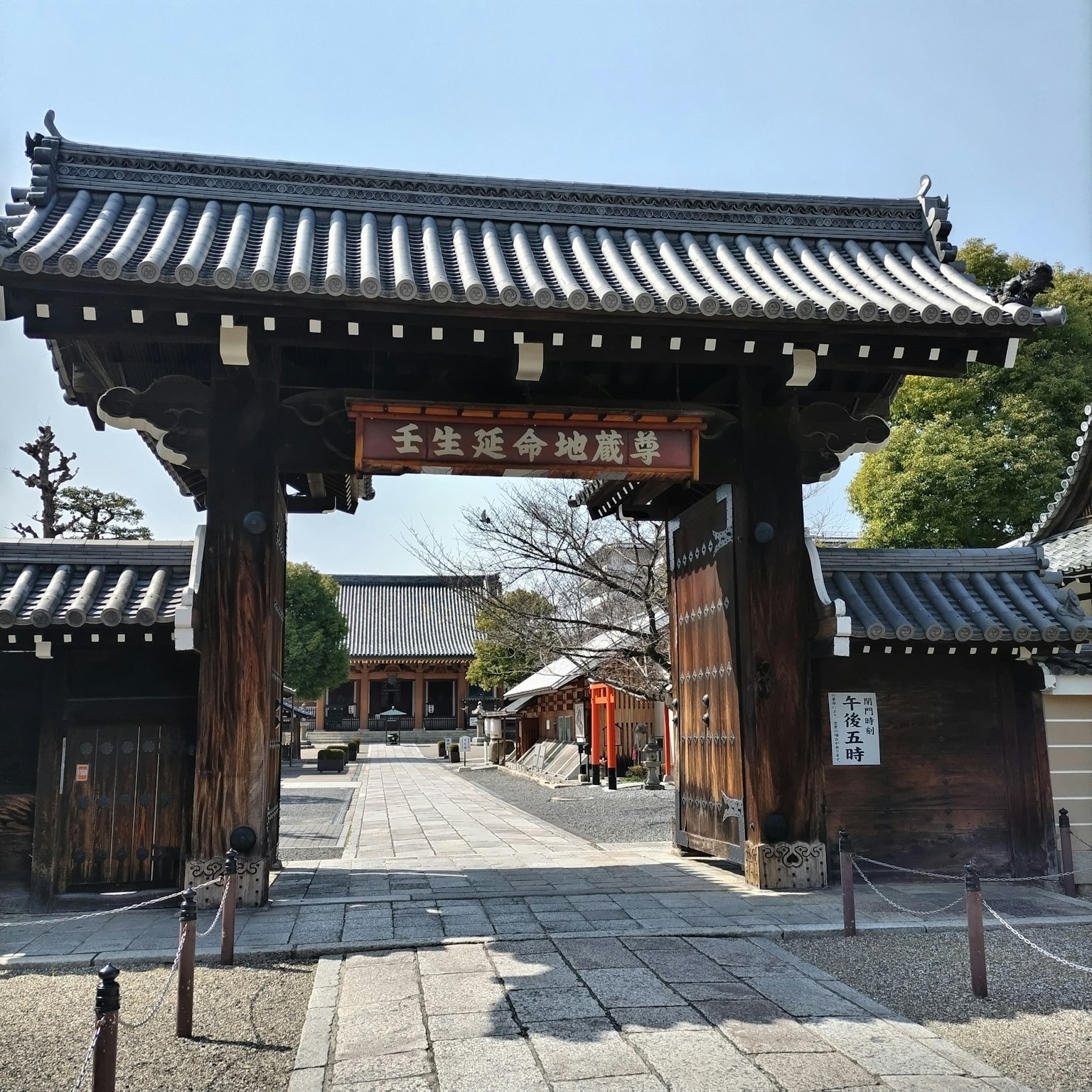 Puerta de templo japonés tradicional con camino de piedra visible