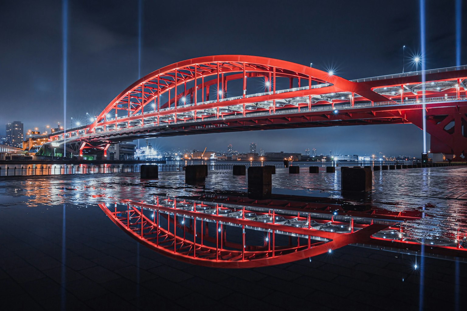 Bella vista di un ponte ad arco rosso che si riflette sull'acqua di notte