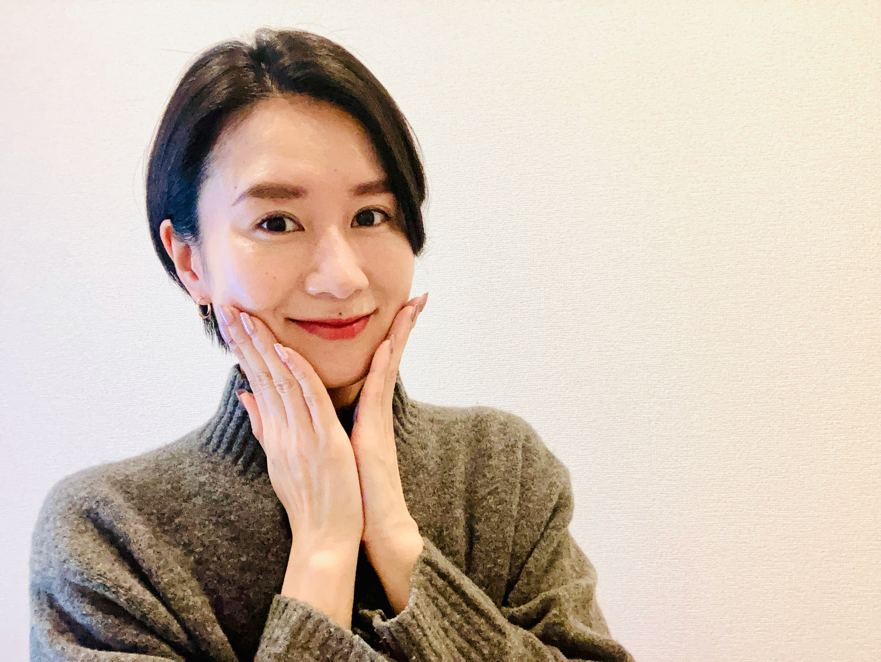 雙手托腮微笑的女性