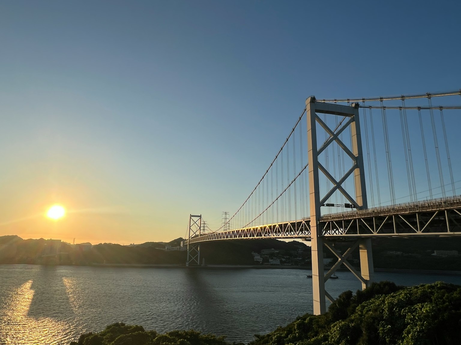 Hermosa vista de un puente sobre el mar con un atardecer brillante