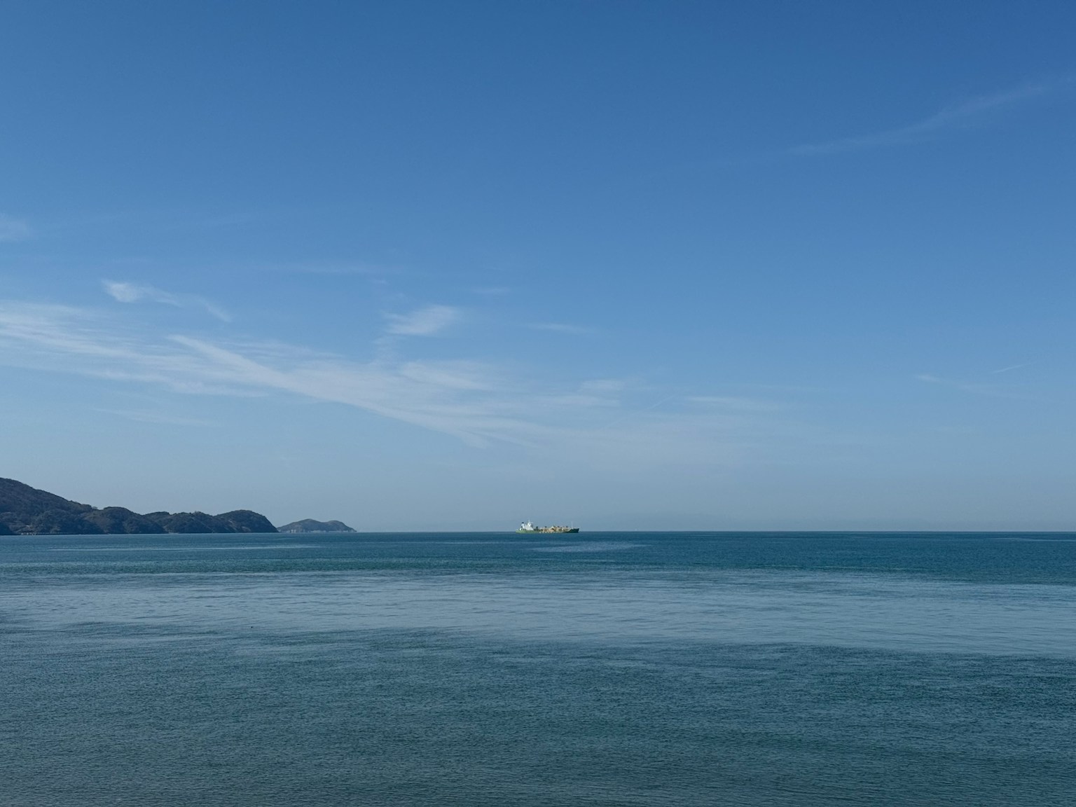 Scenic view of blue sea and sky with a distant ship