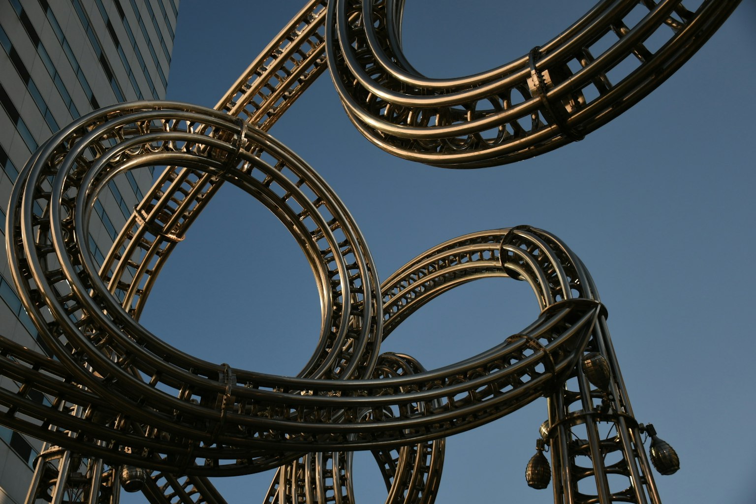 Struktur logam mirip roller coaster di bawah langit biru