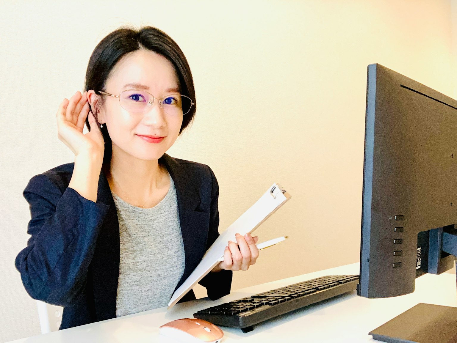 Người phụ nữ mỉm cười đeo kính ngồi ở bàn
