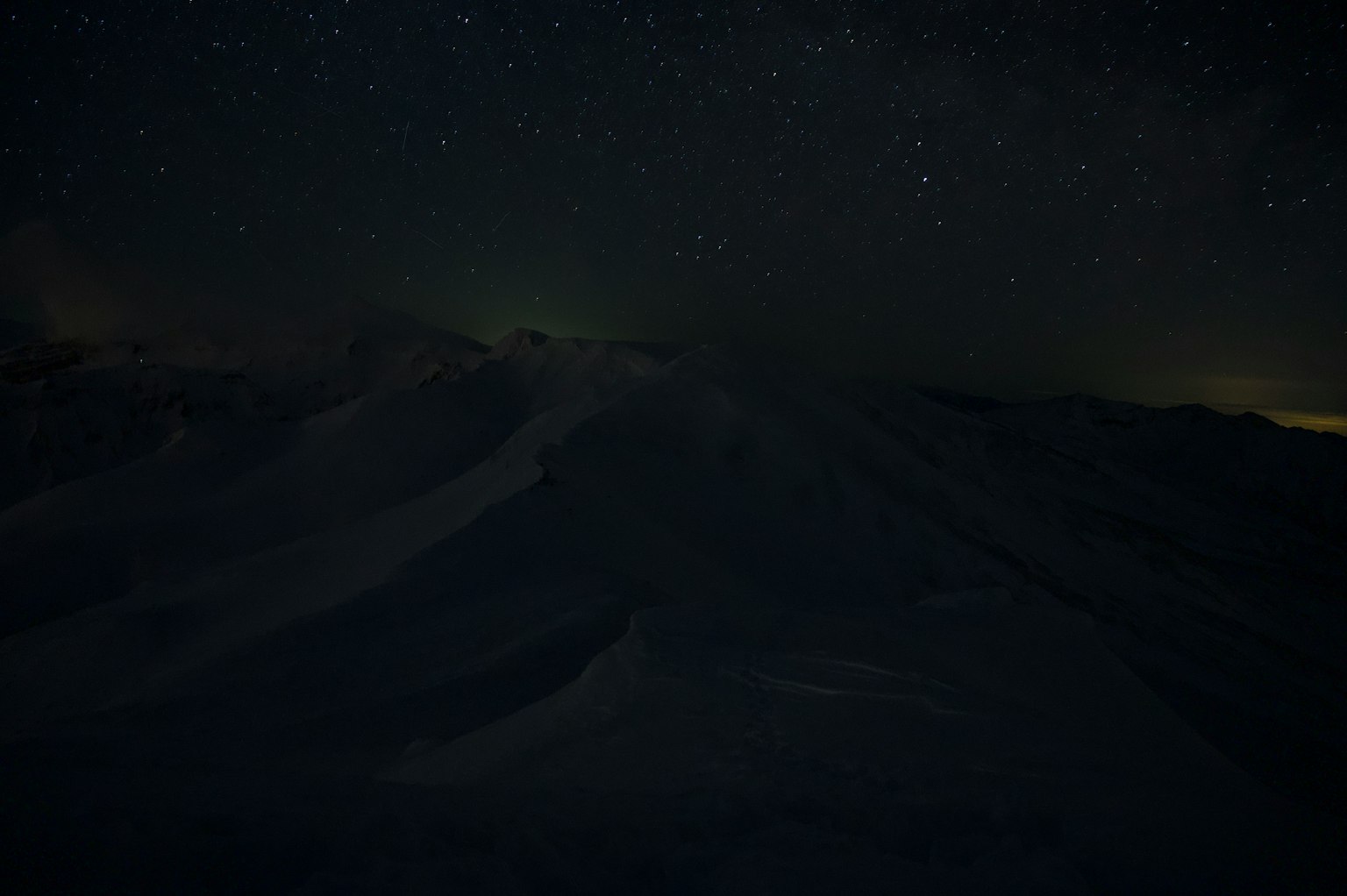 Ciel étoilé au-dessus des montagnes enneigées sombres