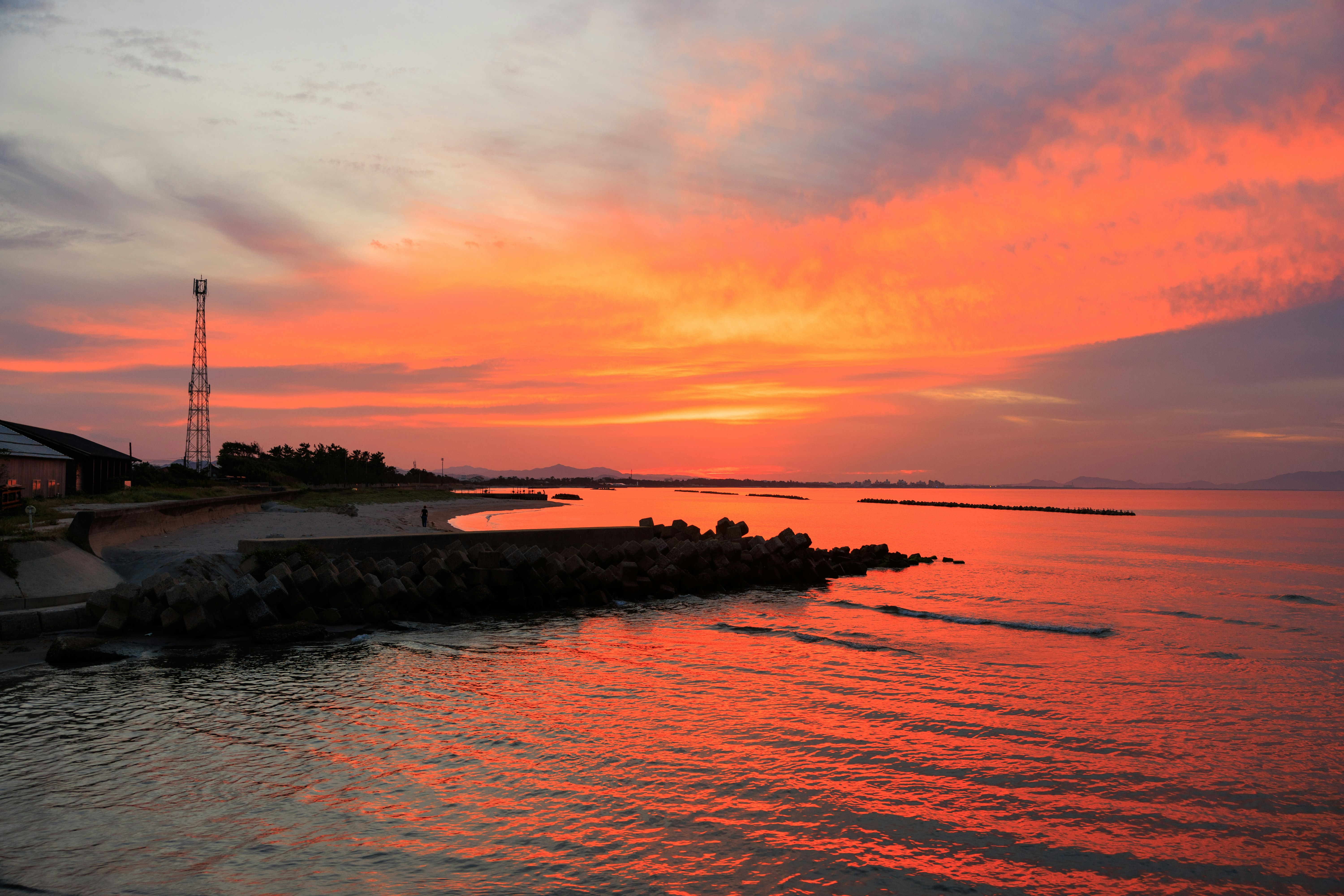 Sonnenuntergang an der Küste mit Wellen am Ufer