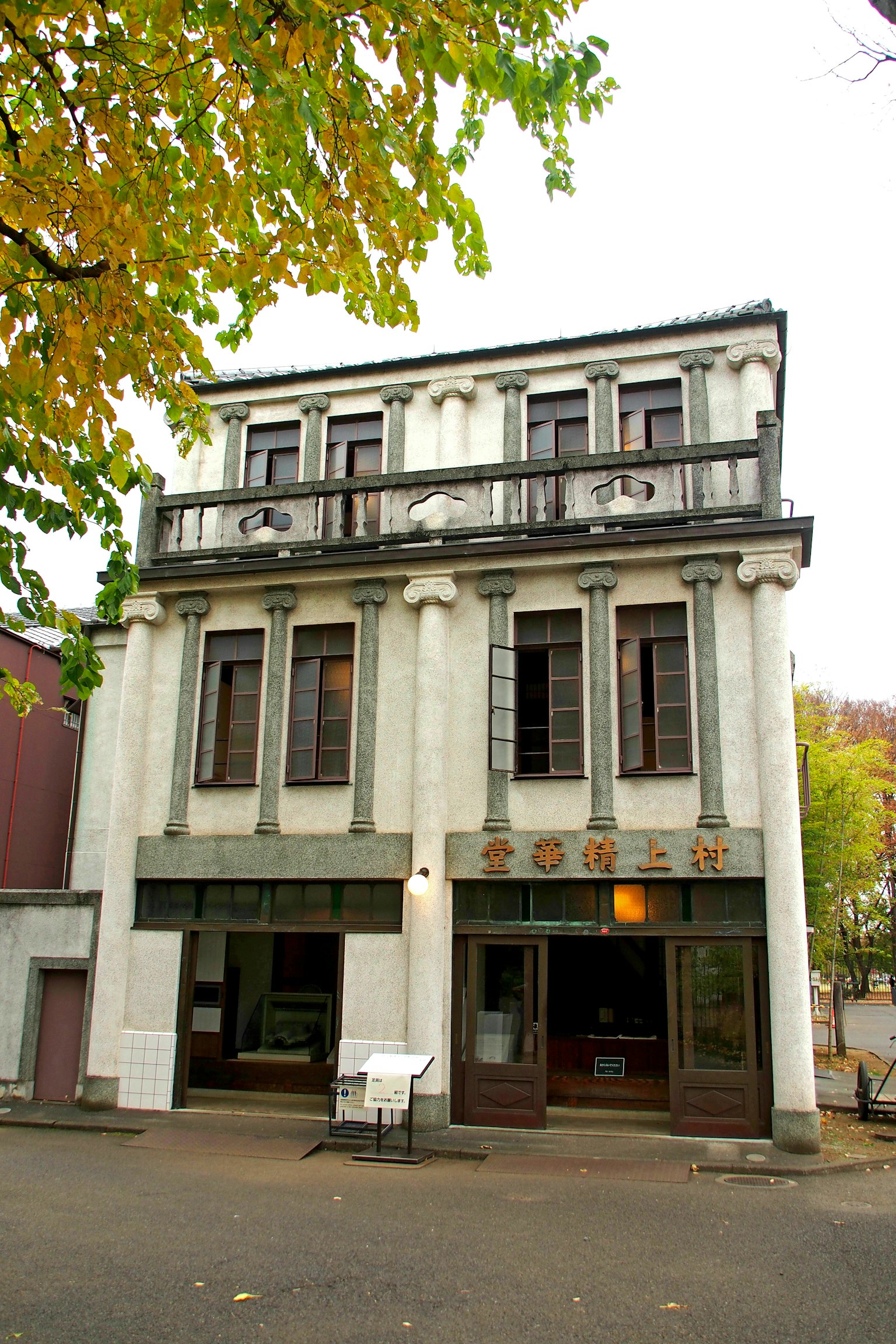 Bâtiment historique de trois étages avec une façade blanche et des colonnes