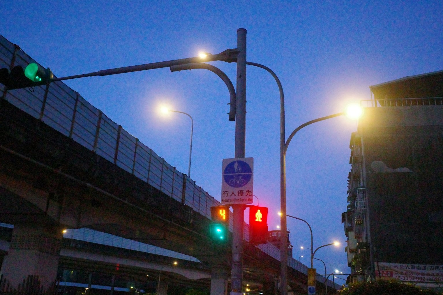 夜の街角の信号機と街灯の風景 高架道路と建物が見える
