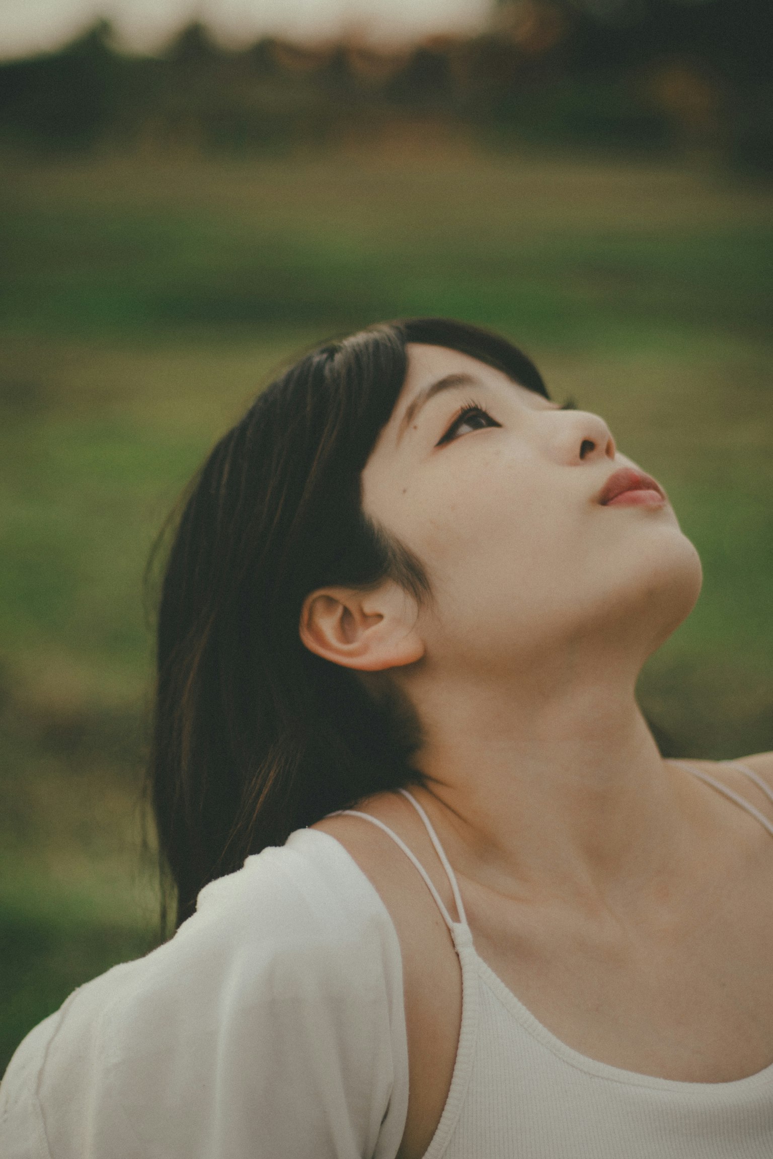 一位女性在自然环境中仰望天空