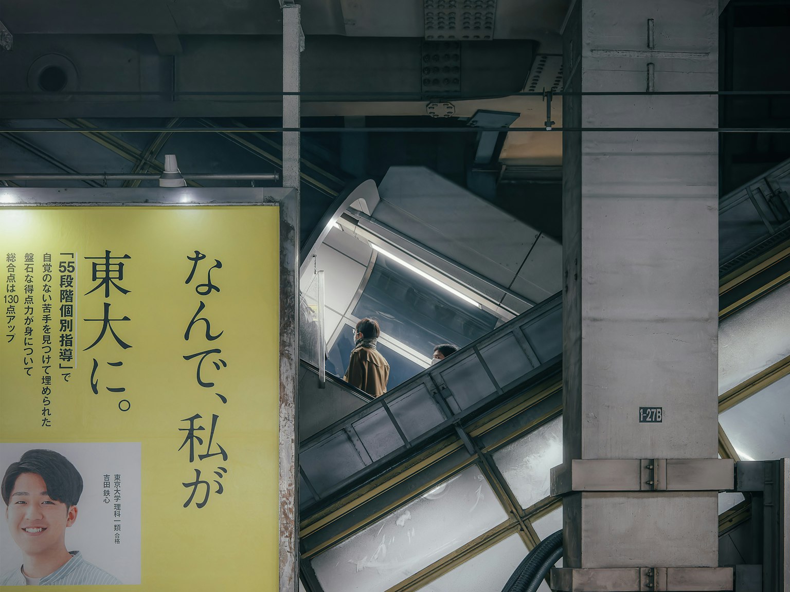 Persone che salgono su una scala mobile in una stazione della metropolitana con una pubblicità in vista