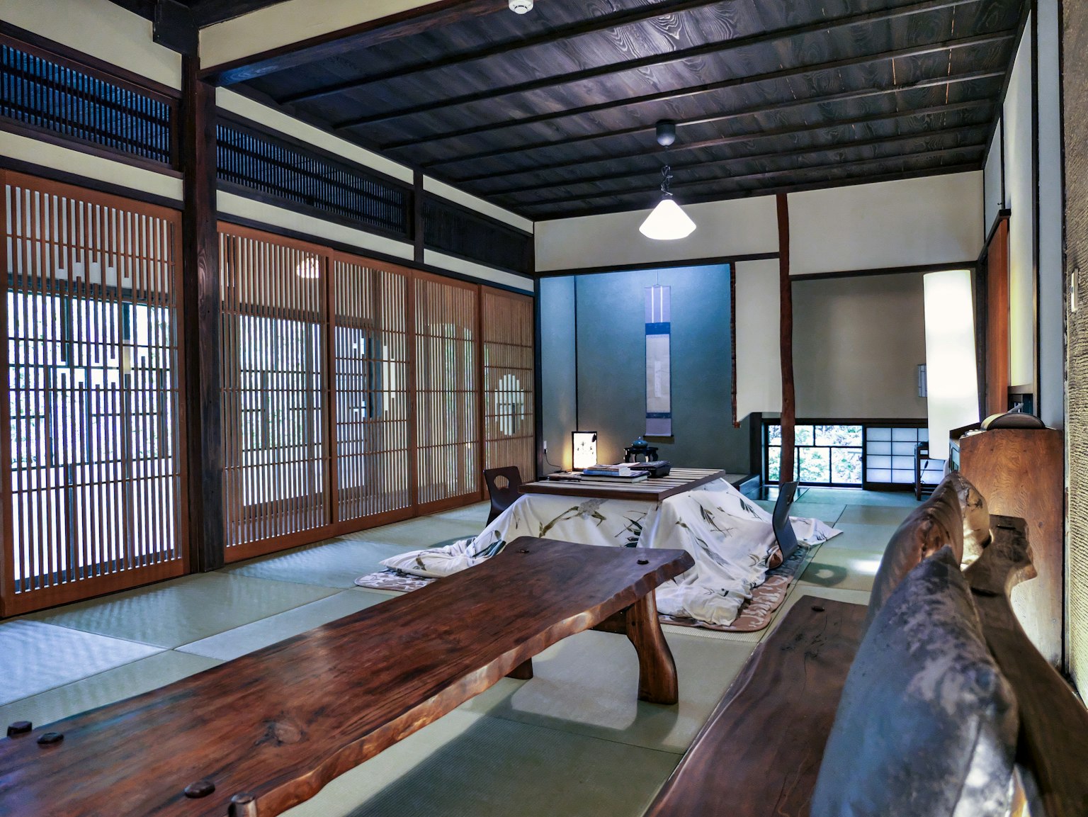 Japanisches Interieur mit einem langen Holztisch und charakteristischen Shoji-Fenstern
