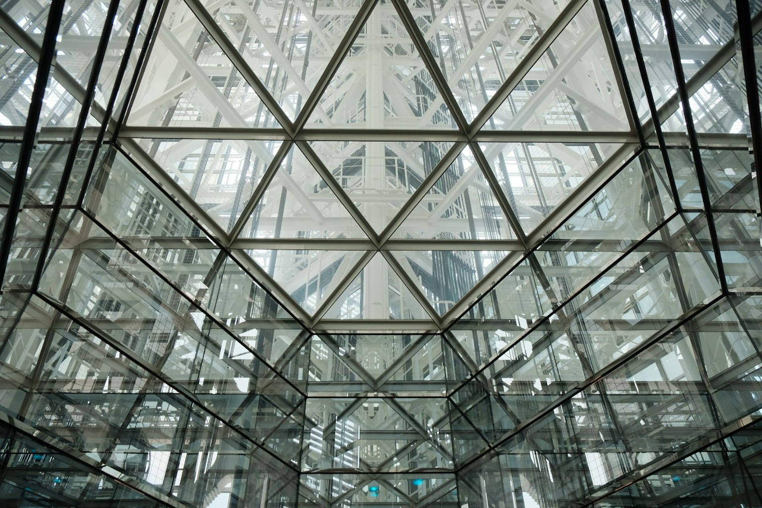 Decke mit sich kreuzenden dreieckigen Mustern aus transparentem Glas und Metallstruktur