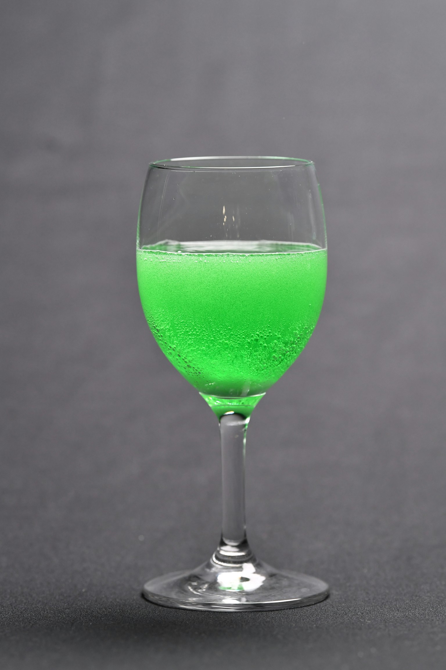 一杯綠色飲料，帶氣泡
