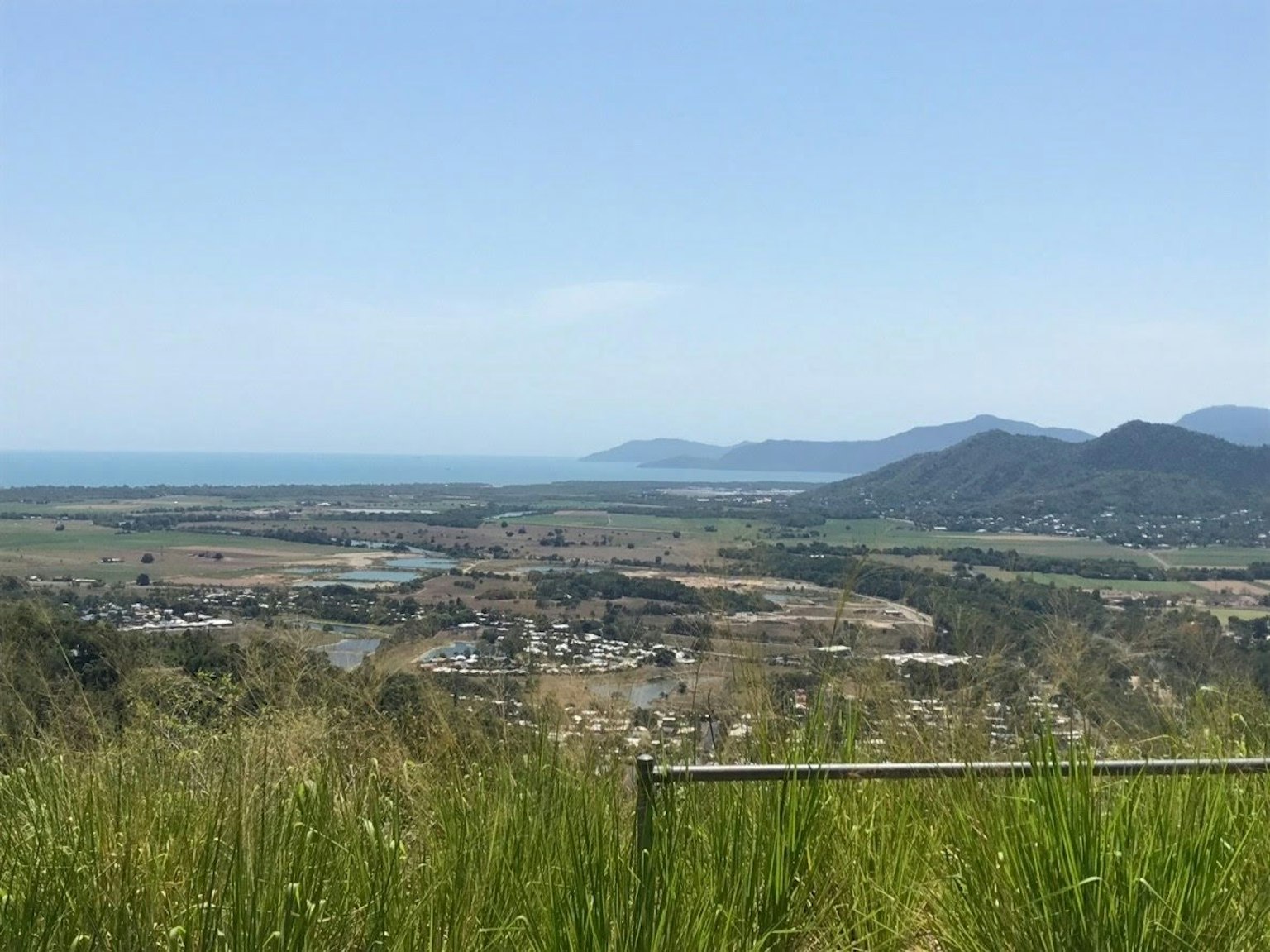 Pemandangan laut dan gunung dengan rumput hijau