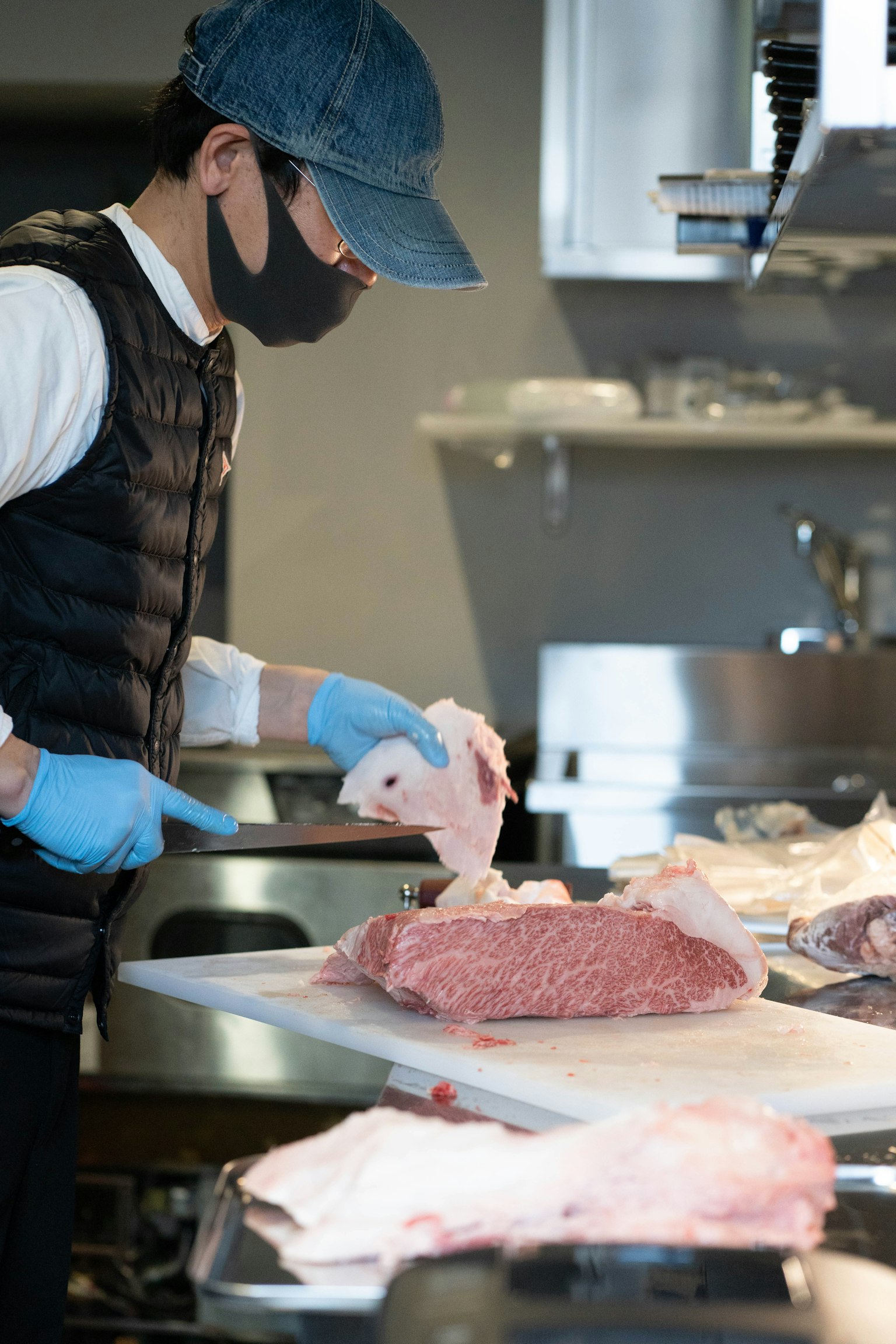 A chef preparing meat in a kitchen setting