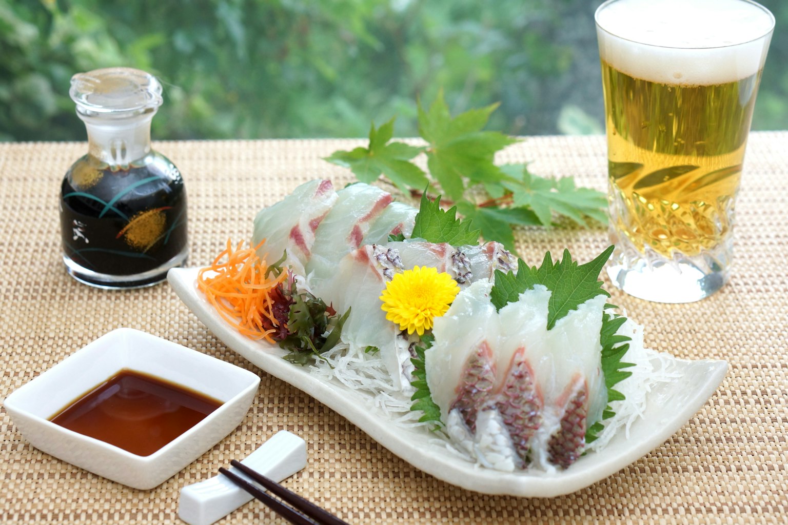 Piring cantik sashimi segar dengan bir dan kecap