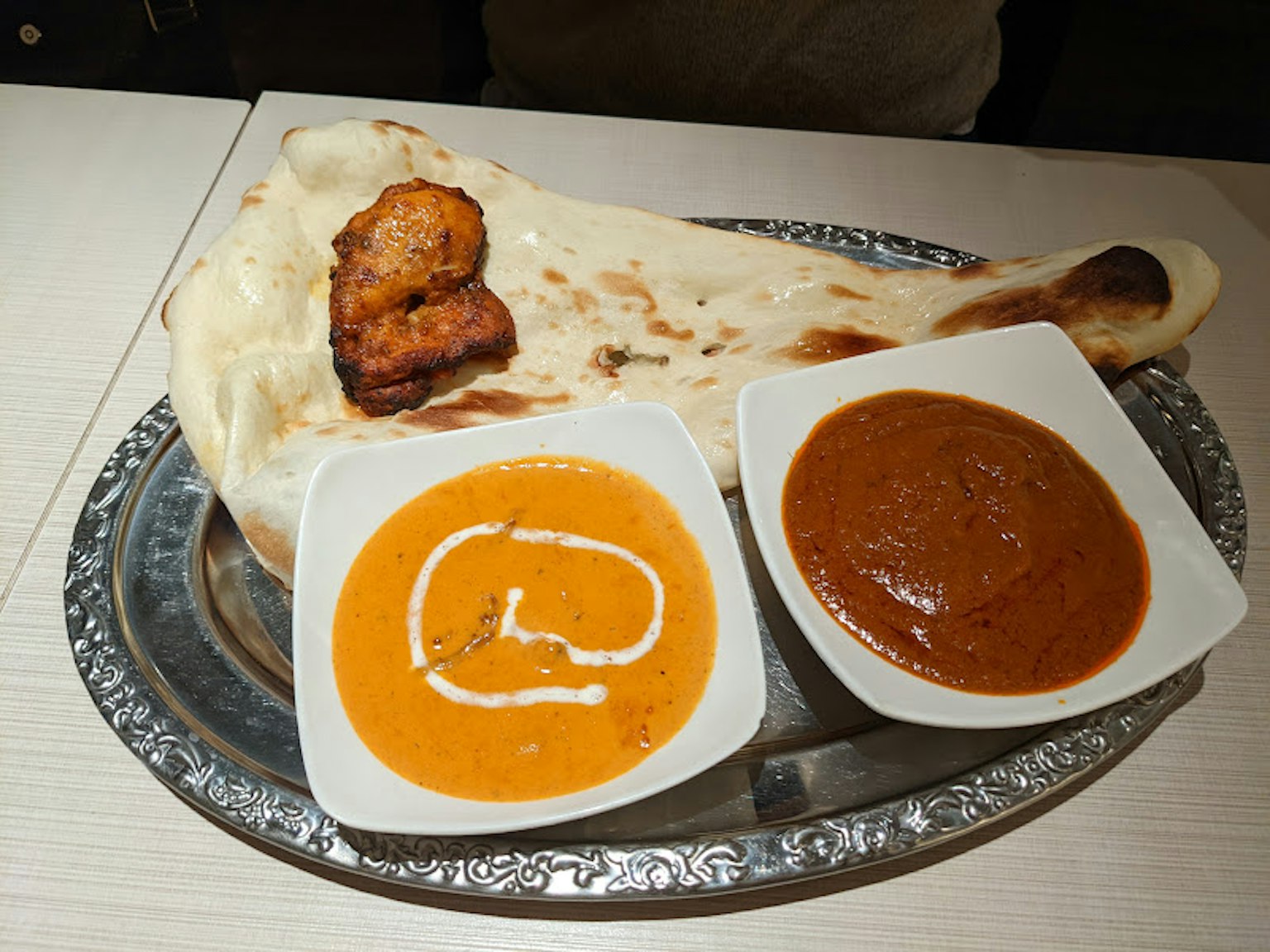 Teller mit Naan-Brot und zwei Currysoßen