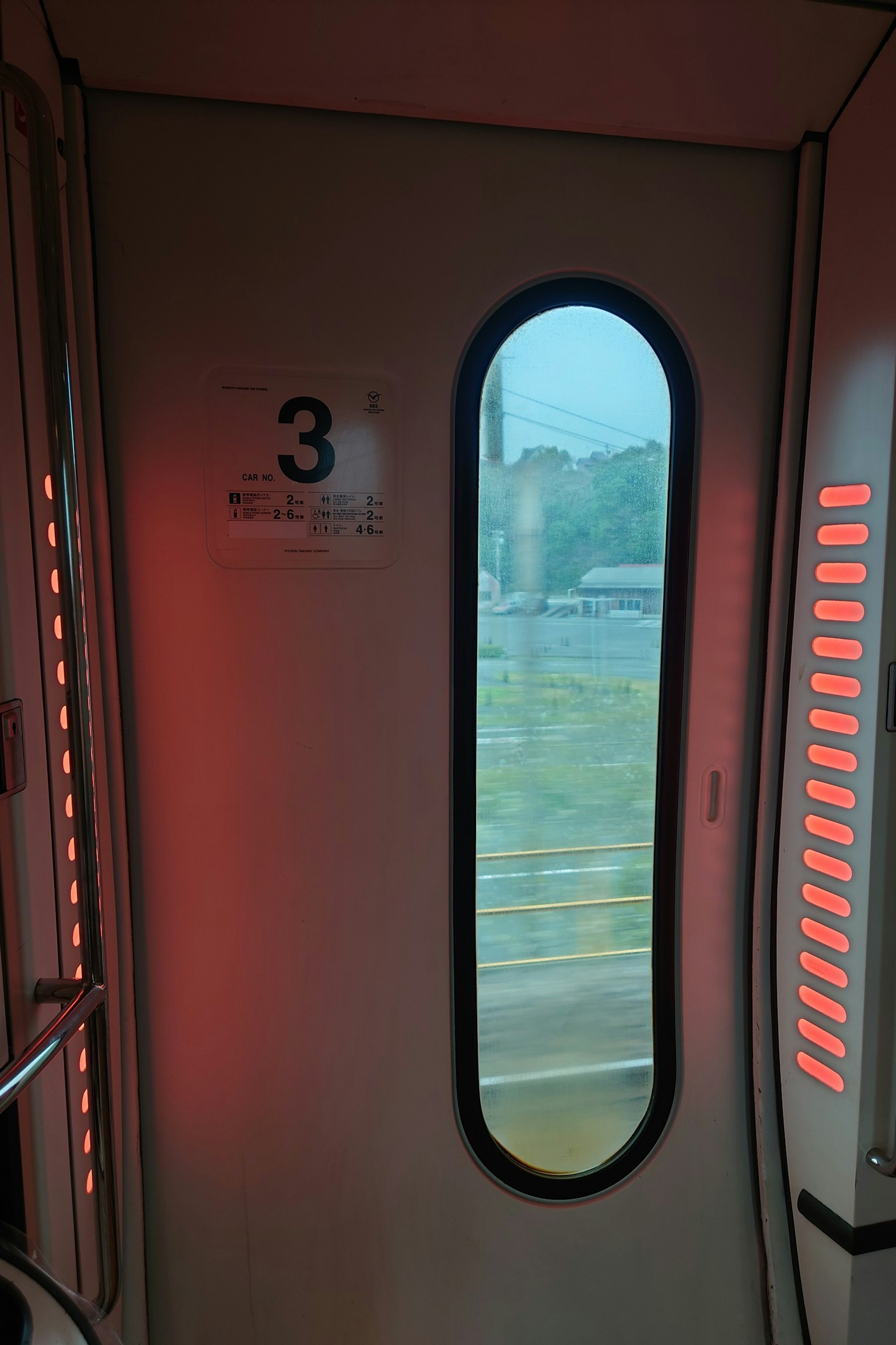 火車門的內部視圖紅色燈光和圓形窗戶顯示外部風景