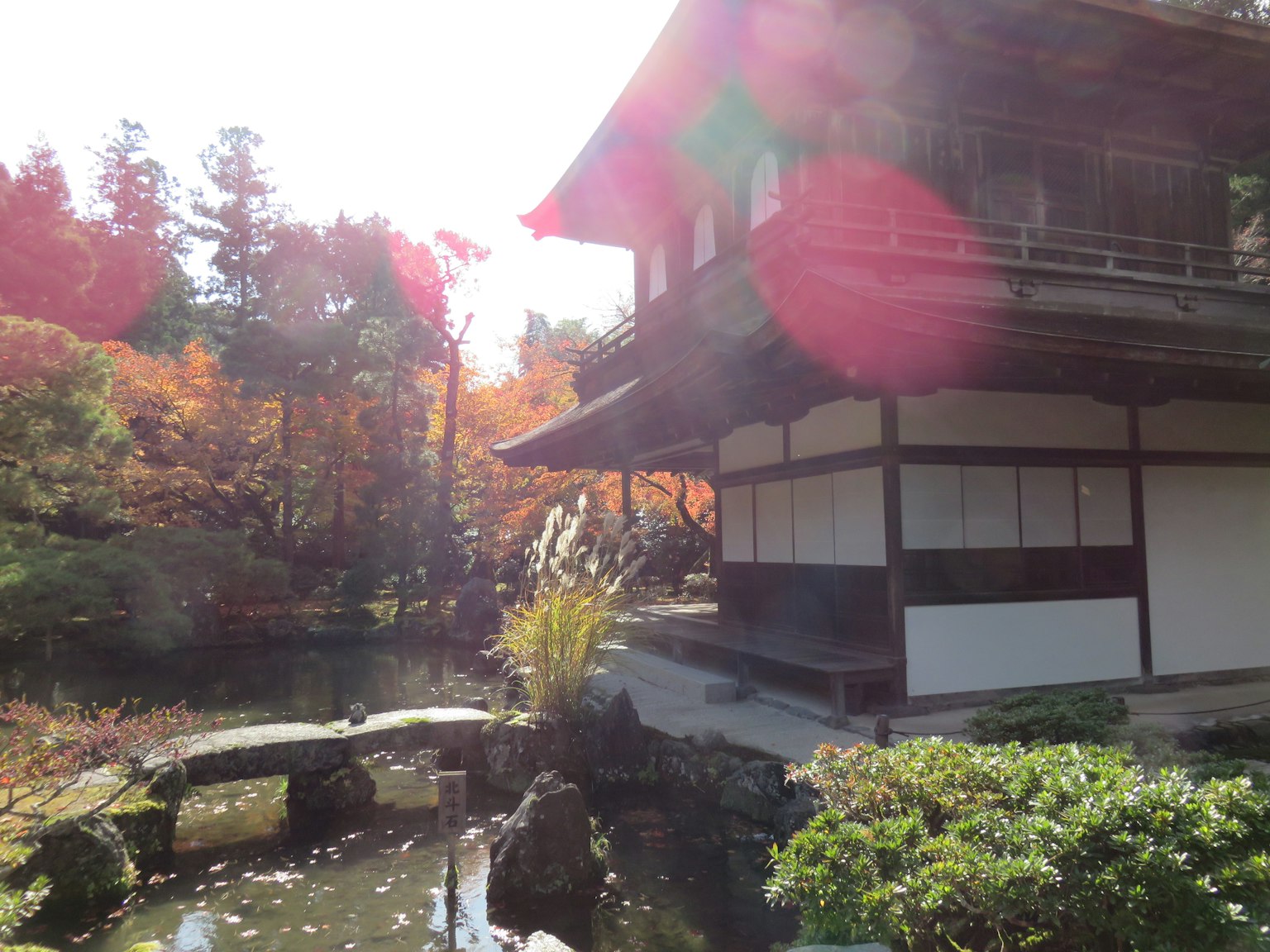 Vista escénica de un edificio japonés tradicional junto a un sereno estanque de jardín