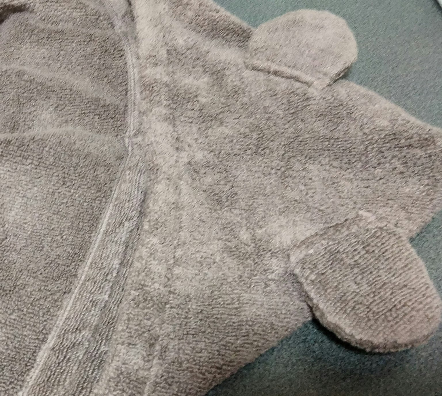 Parte de una bata con capucha gris de tela de toalla con diseño de orejas