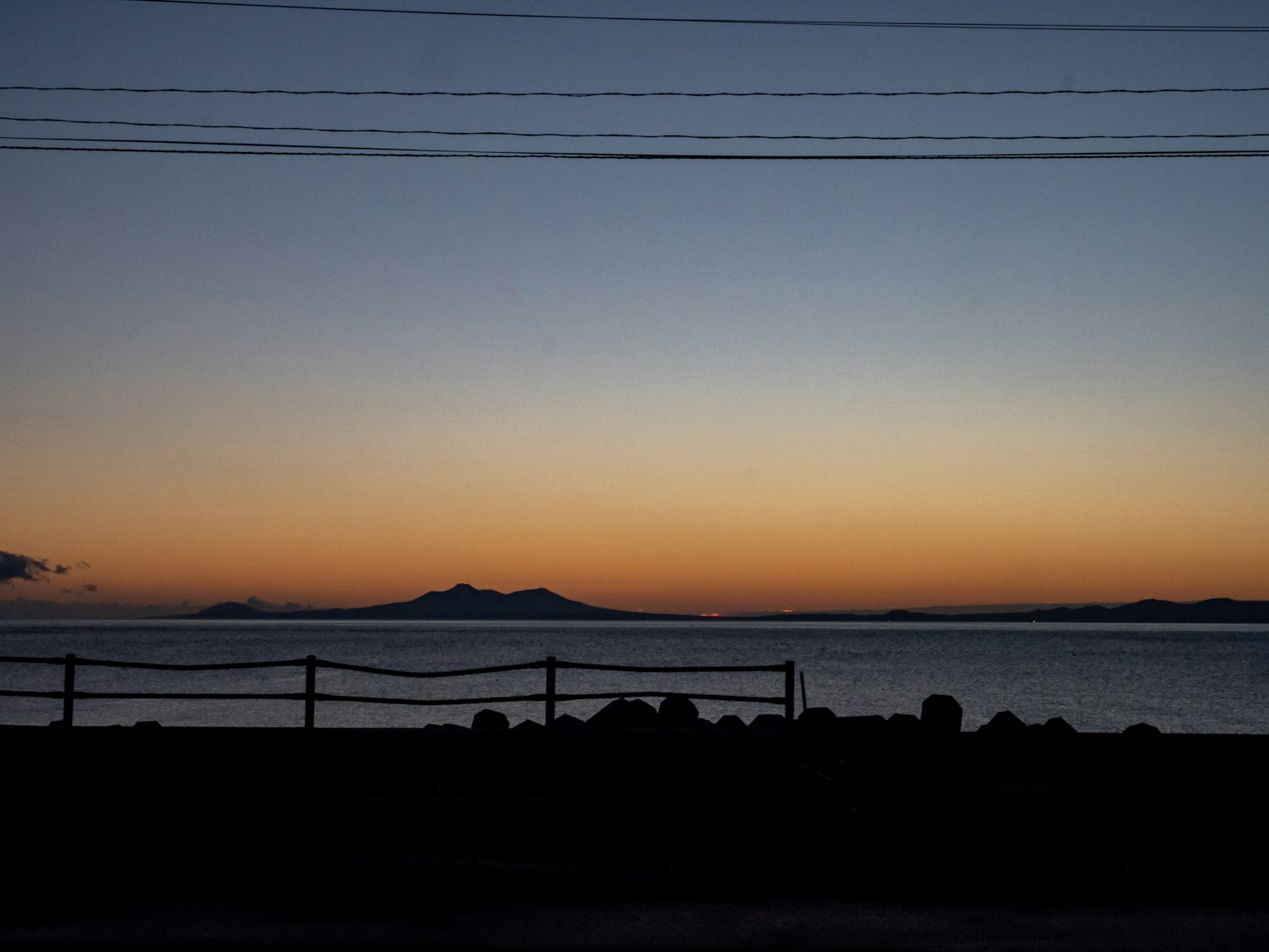 Silhouette von Bergen bei Sonnenuntergang über dem Meer