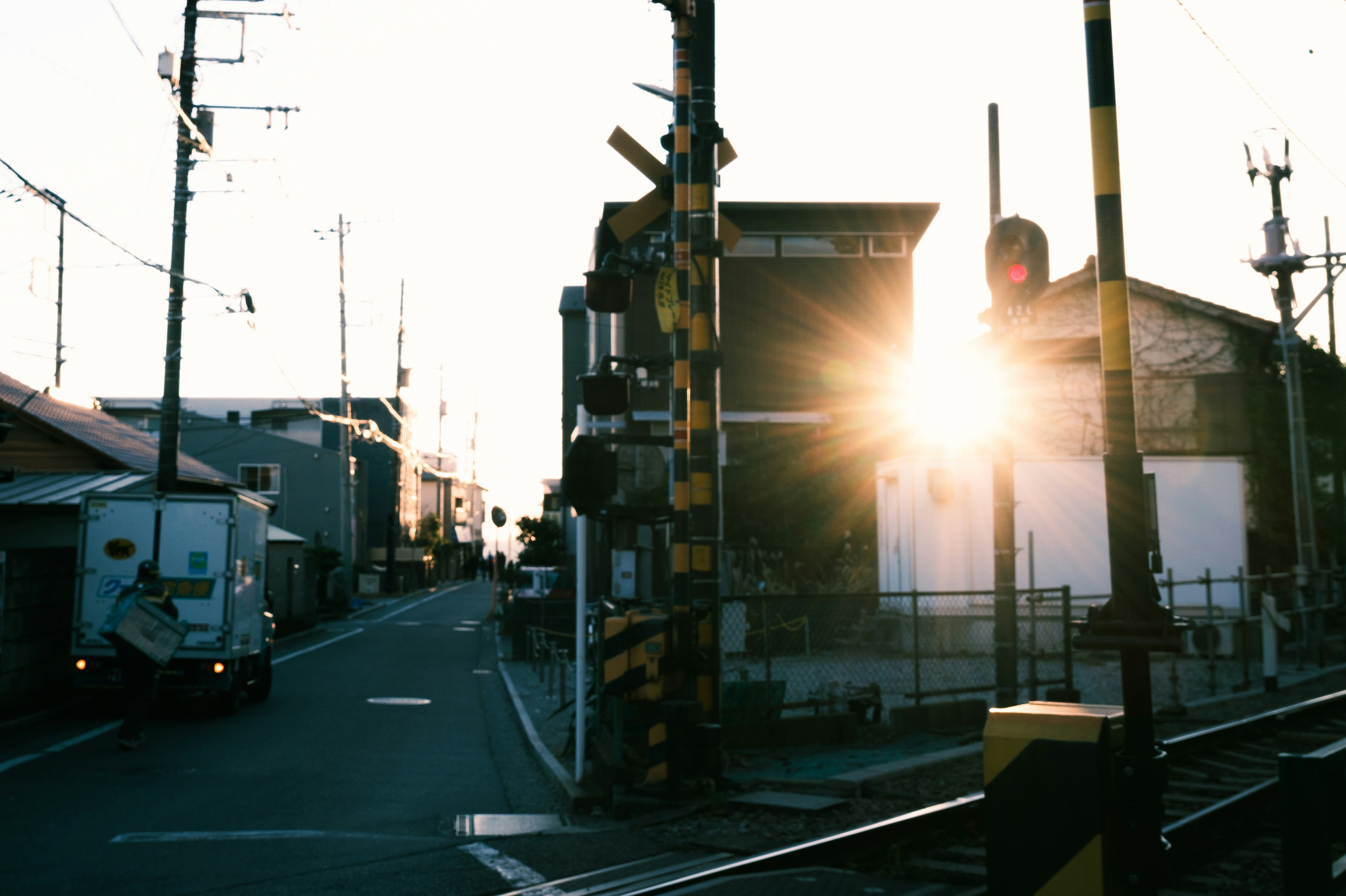 夕焼けの街角を走る車と信号のある路地