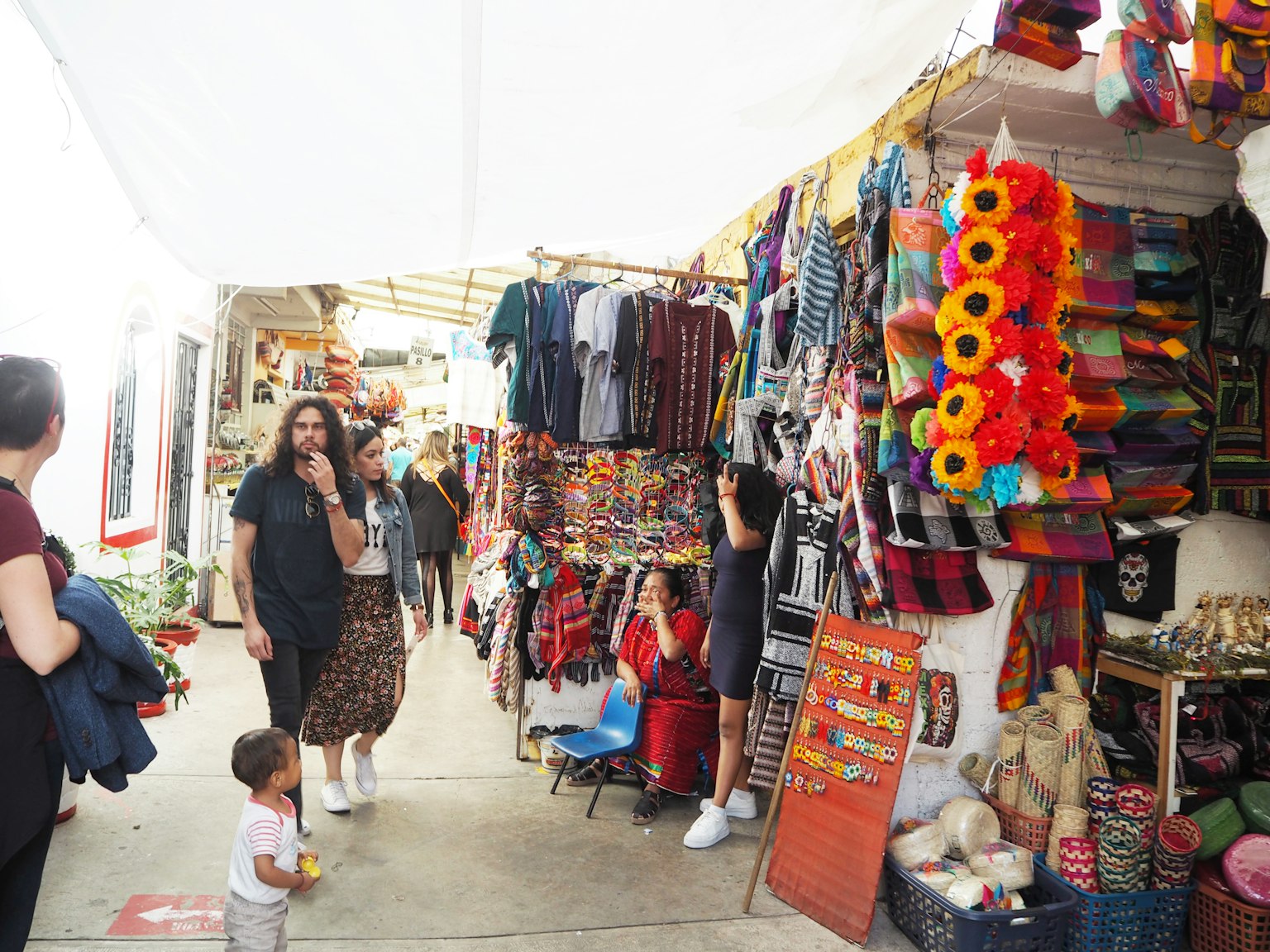 ถนนตลาดที่คึกคักมีแผงขายของสีสันสดใสและผู้ซื้อ
