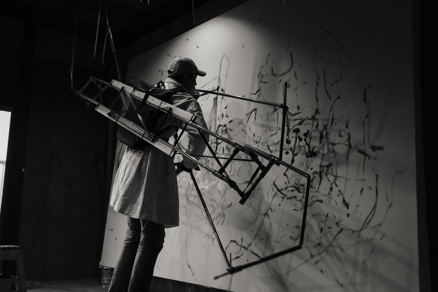 黒と白の背景に抽象的なアートを描く人物