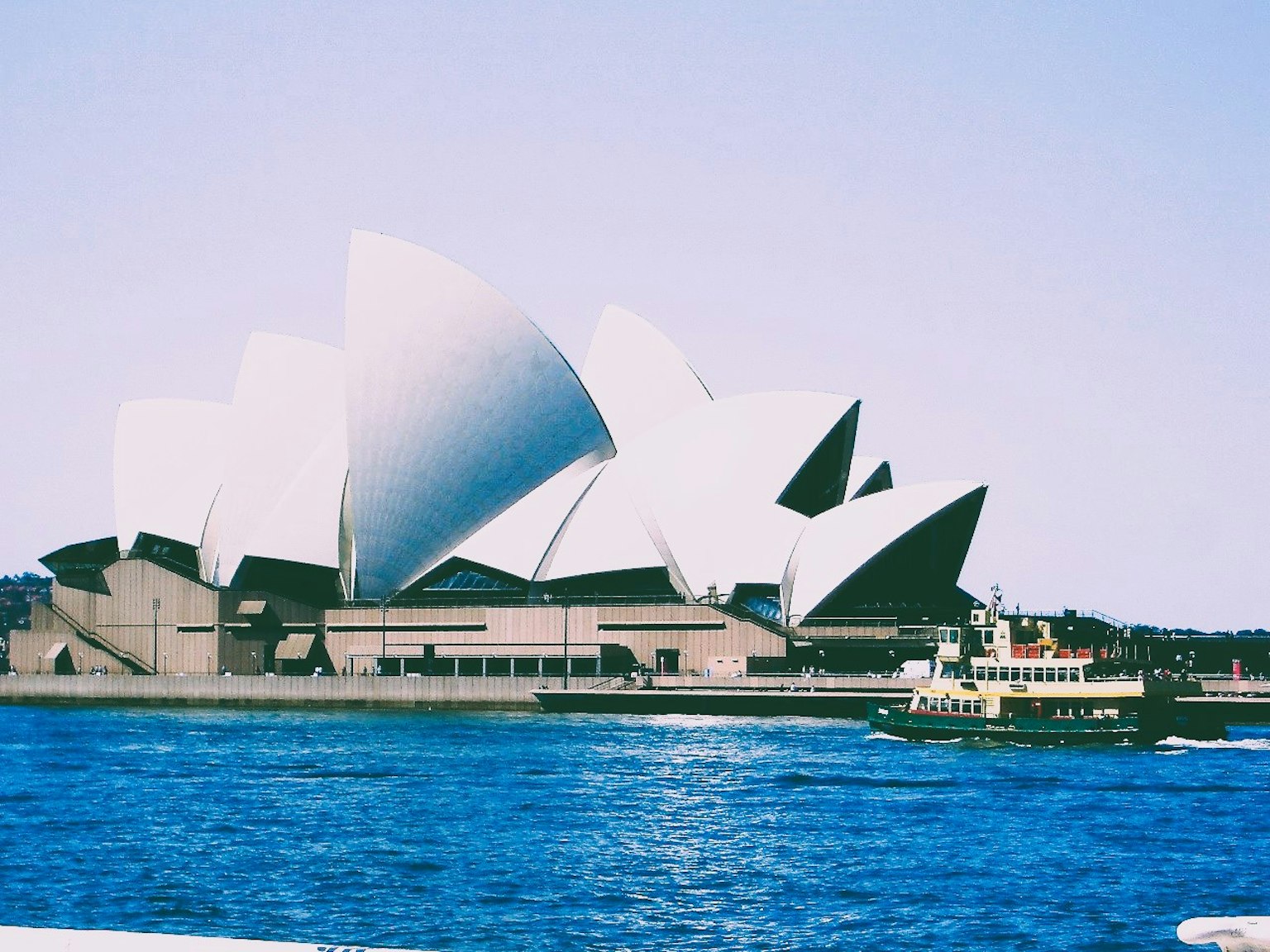 Sydney Opera House with distinctive white sail-like design and blue water contrast