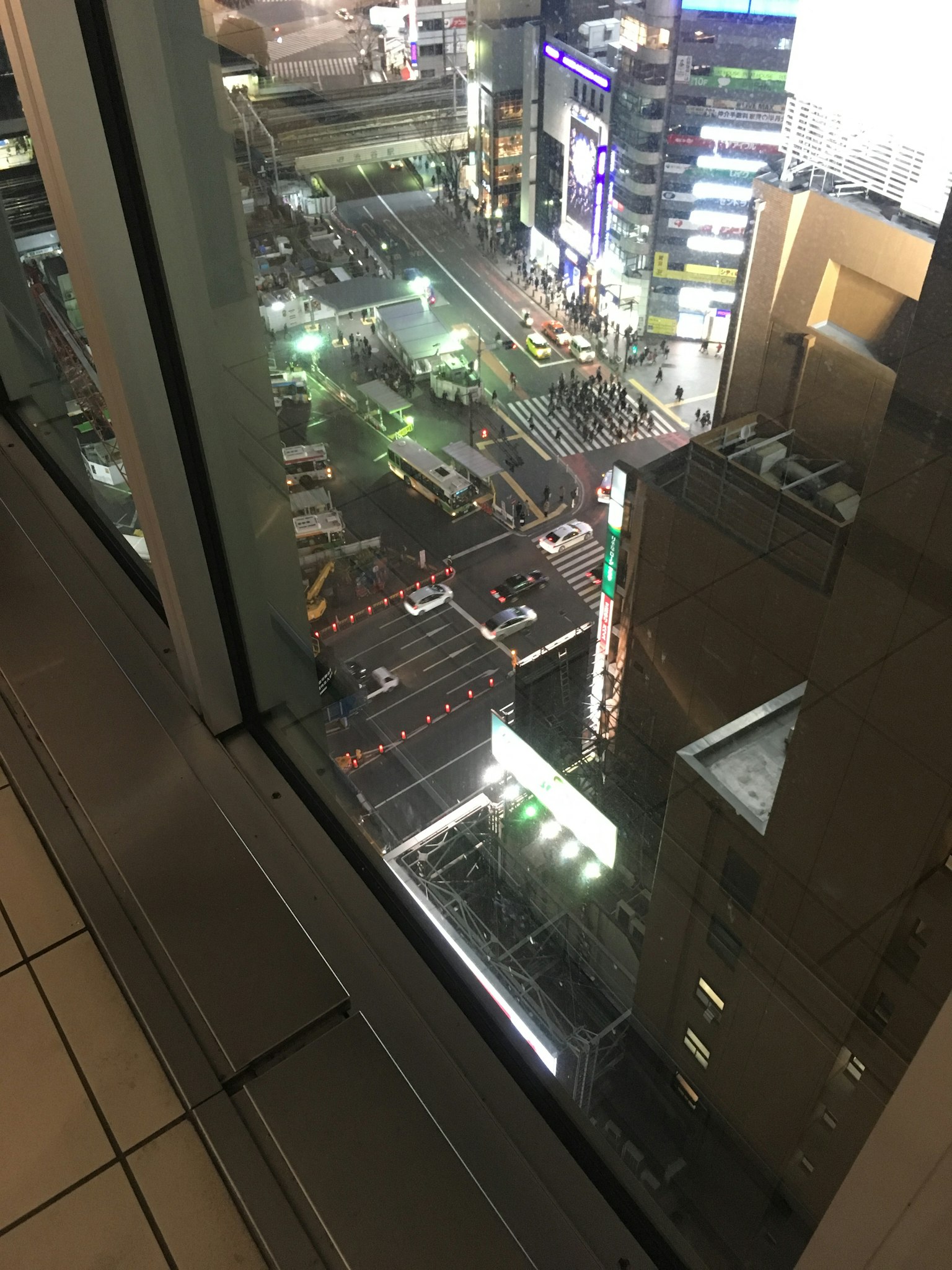 高樓大廈窗外的城市夜景顯示街道和行人活動