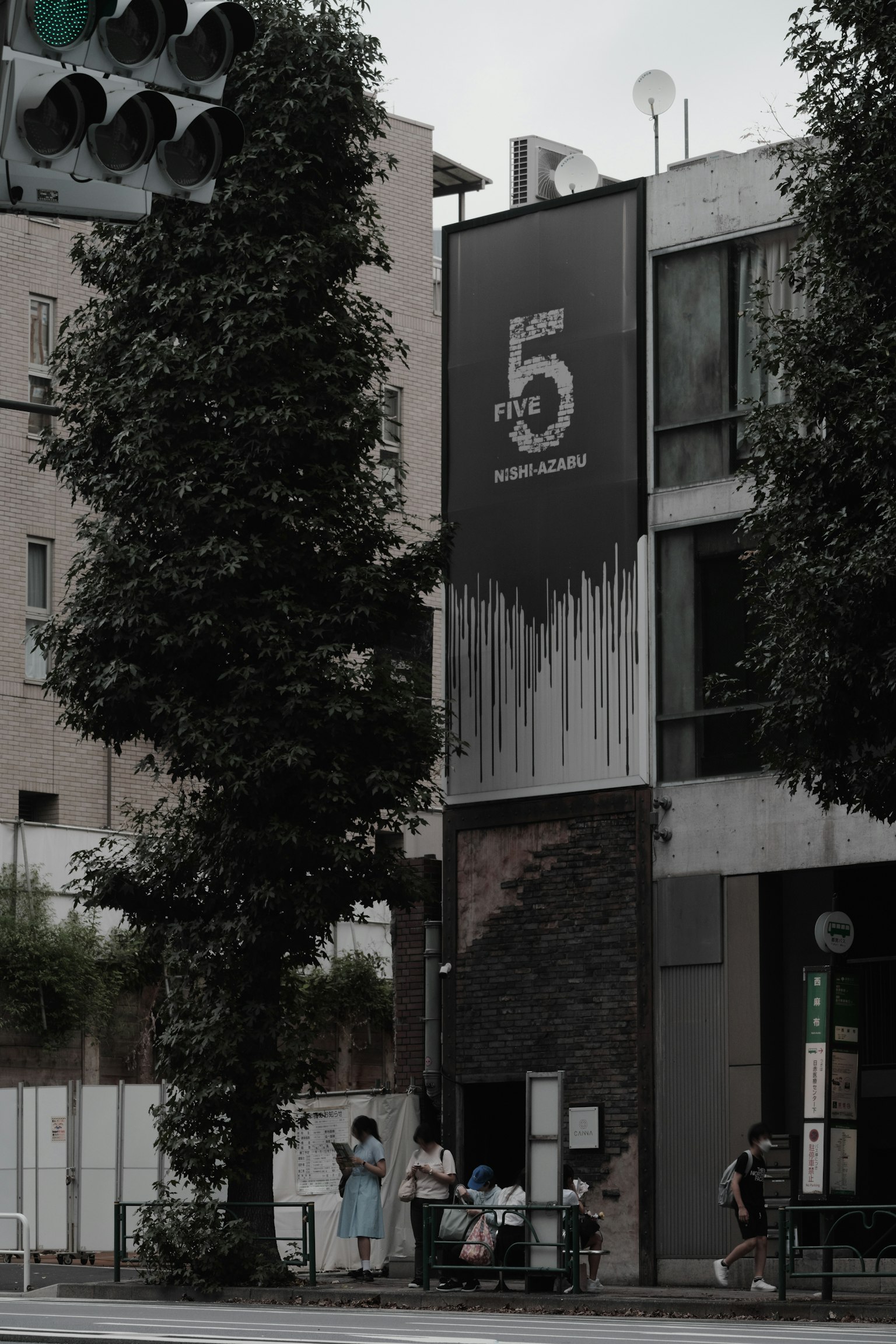 Fachada de edificio en la esquina de la calle con árboles verdes prominentes