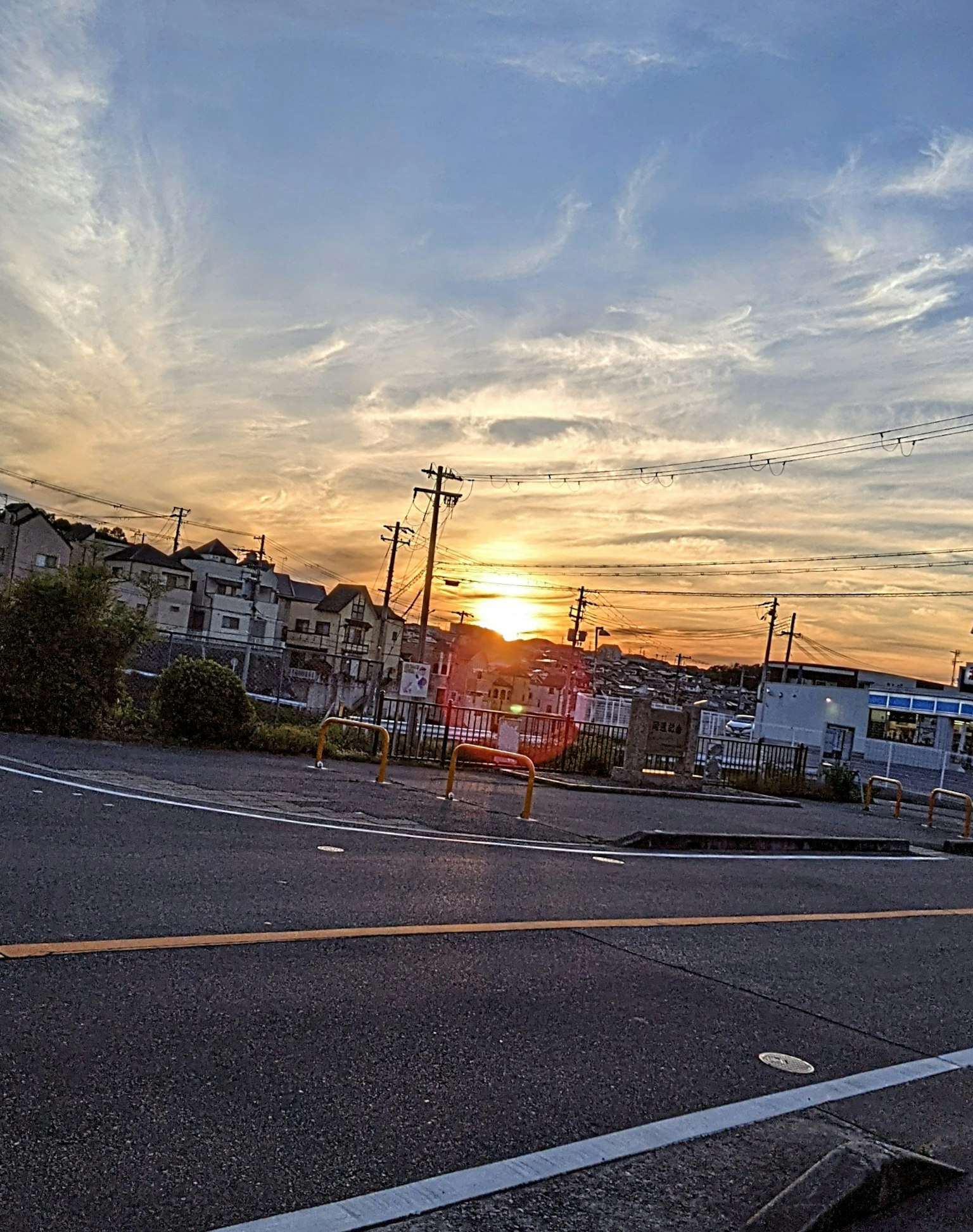 Stadtlandschaft bei Sonnenuntergang mit Häusern und Stromleitungen