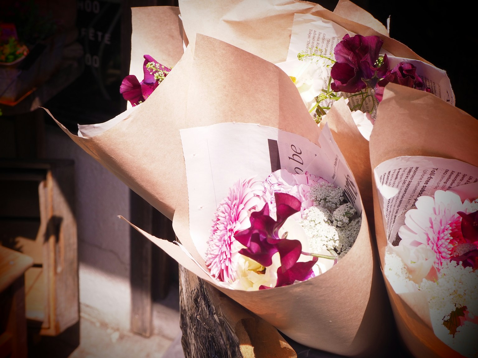 Des bouquets de fleurs colorées enveloppés dans du papier sont exposés