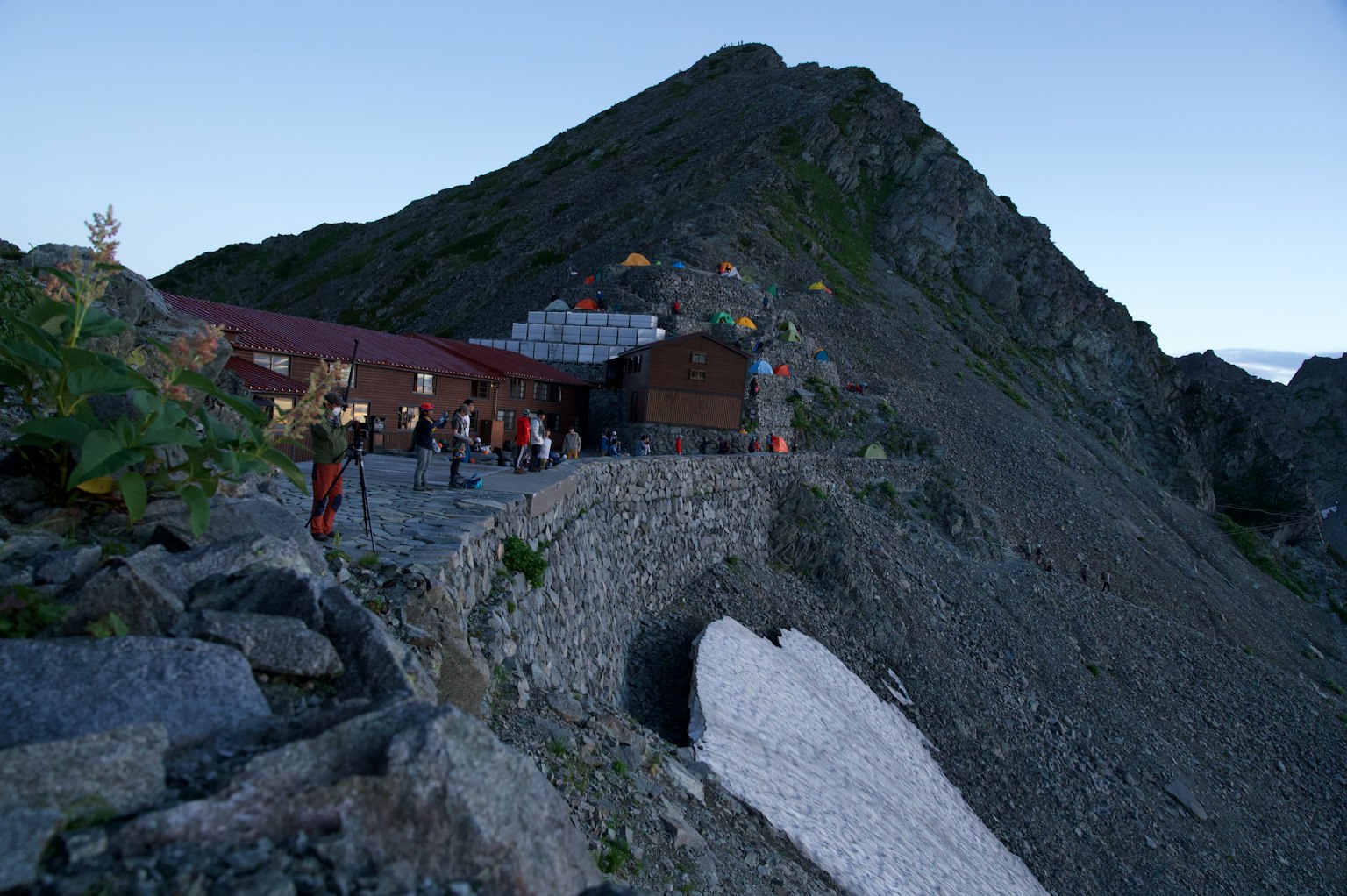 黄昏时分的山屋与徒步旅行者