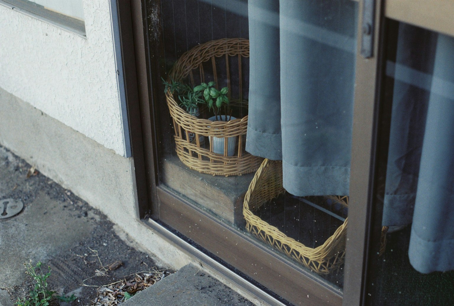 窓の近くに置かれた二つのかごとカーテンのある風景