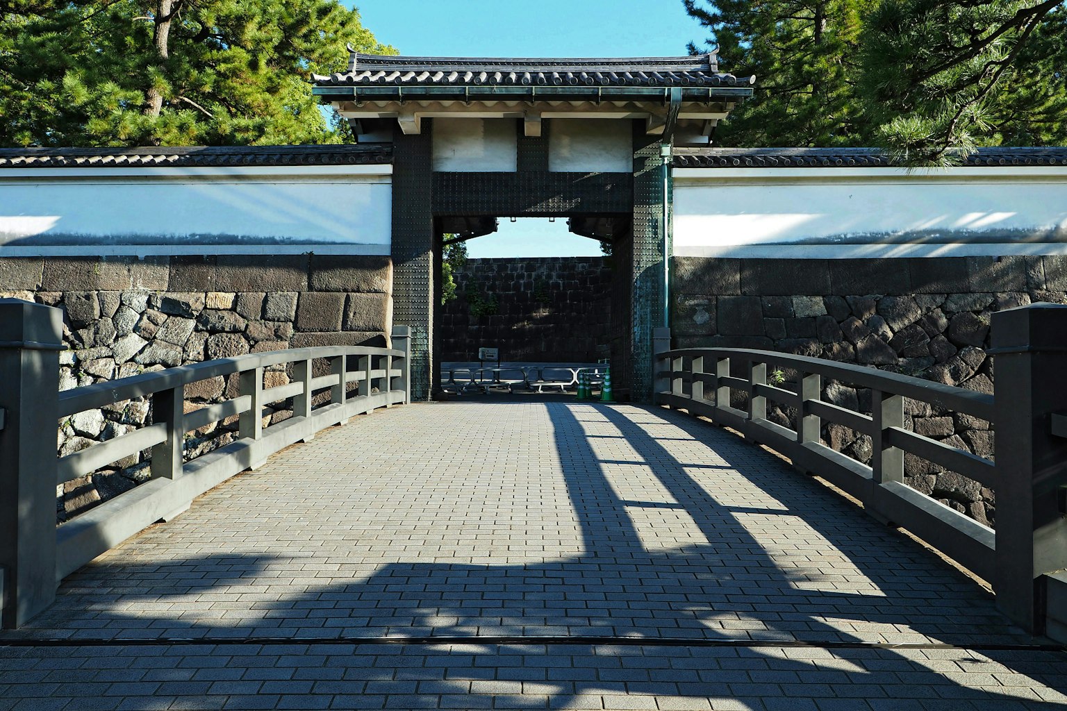 Traditional Japanese gate and bridge scene with visible stone walls and trees