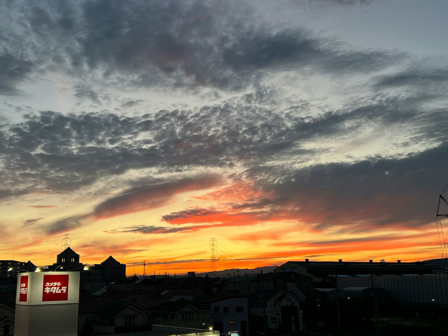 Silhouette de bâtiments contre un ciel de coucher de soleil coloré avec des nuages