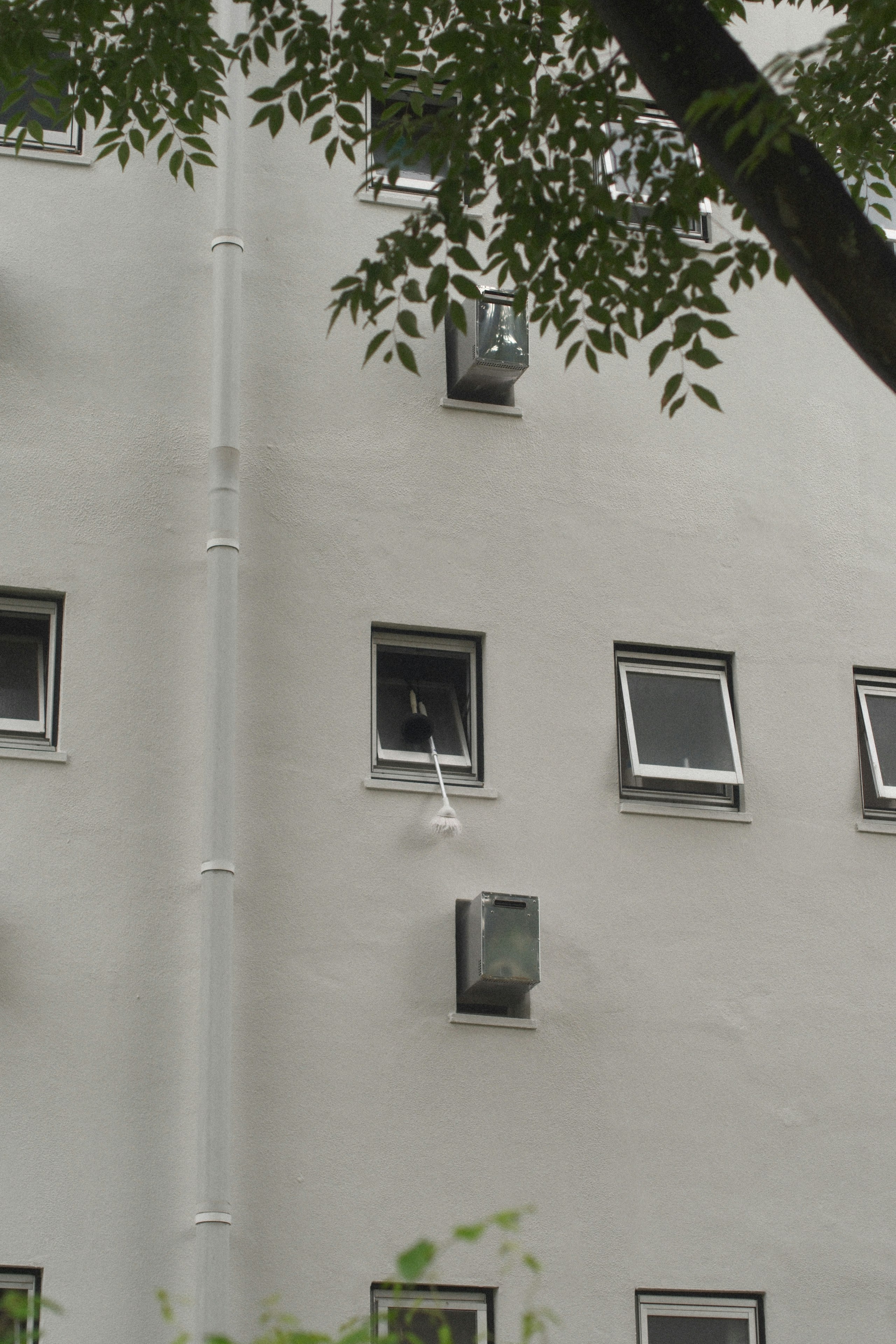Fachada de un edificio con una fila de ventanas y tuberías